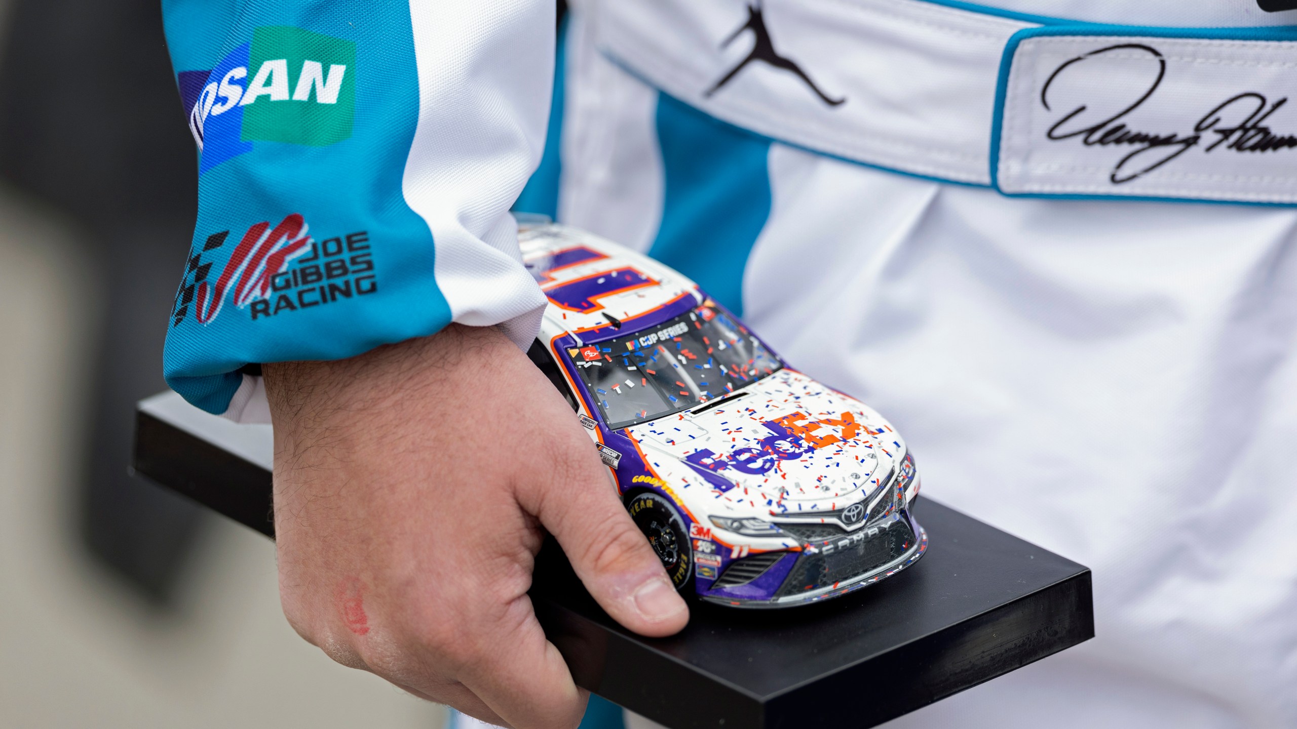 Denny Hamlin fan Will Signor, from Gettysburg, Penn., holds a model car as he waits for an autograph before a NASCAR Cup Series auto race, Sunday, March 17, 2024, in Bristol, Tenn. (AP Photo/Wade Payne)