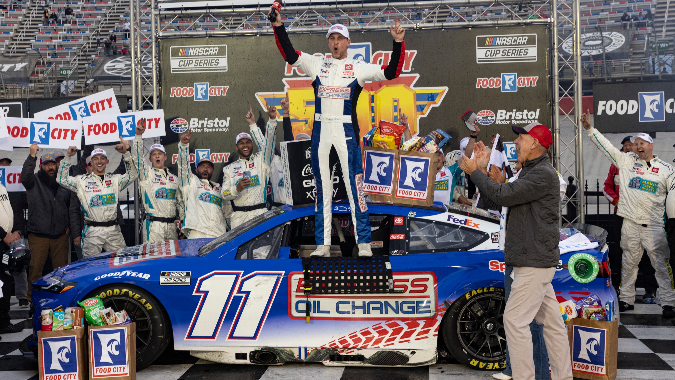 Denny Hamlin, centro, celebra después de ganar la carrera de la Copa NASCAR Series, el domingo 17 de marzo de 2024, en Bristol, Tennessee. (AP Foto/Wade Payne)