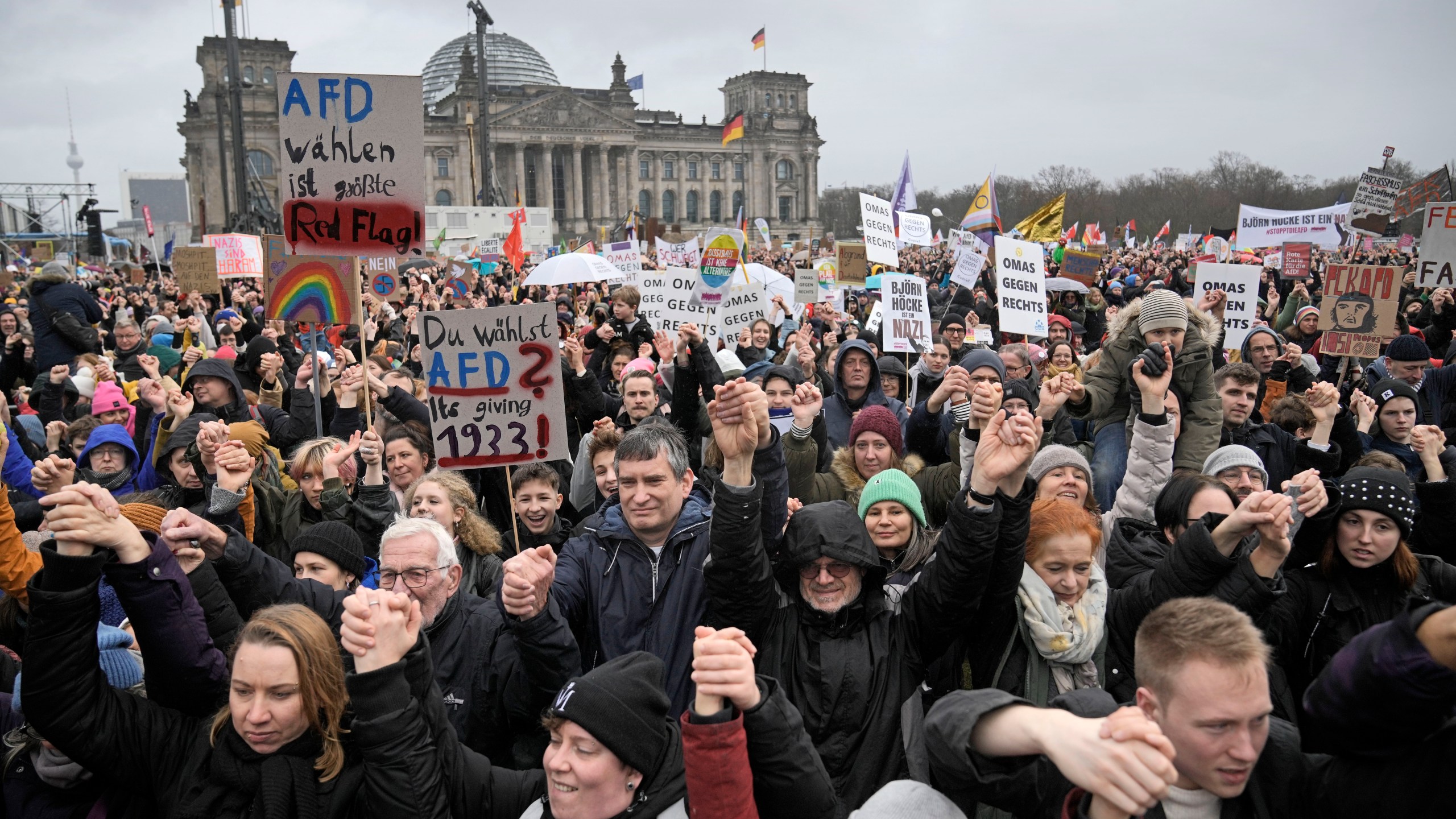 FILE - People hold hands in front of Germany's parliament at a demonstration against the far-right Alternative for Germany, or AfD, party and right-wing extremism in Berlin, Germany, Saturday, Feb. 3, 2024. Millions of Germans have joined rallies all over the country for weeks in a row, attending events with slogans such as "Never Again is Now." The protesters have been alarmed by the AfD's policies and its growing popularity. (AP Photo/Ebrahim Noroozi, File)
