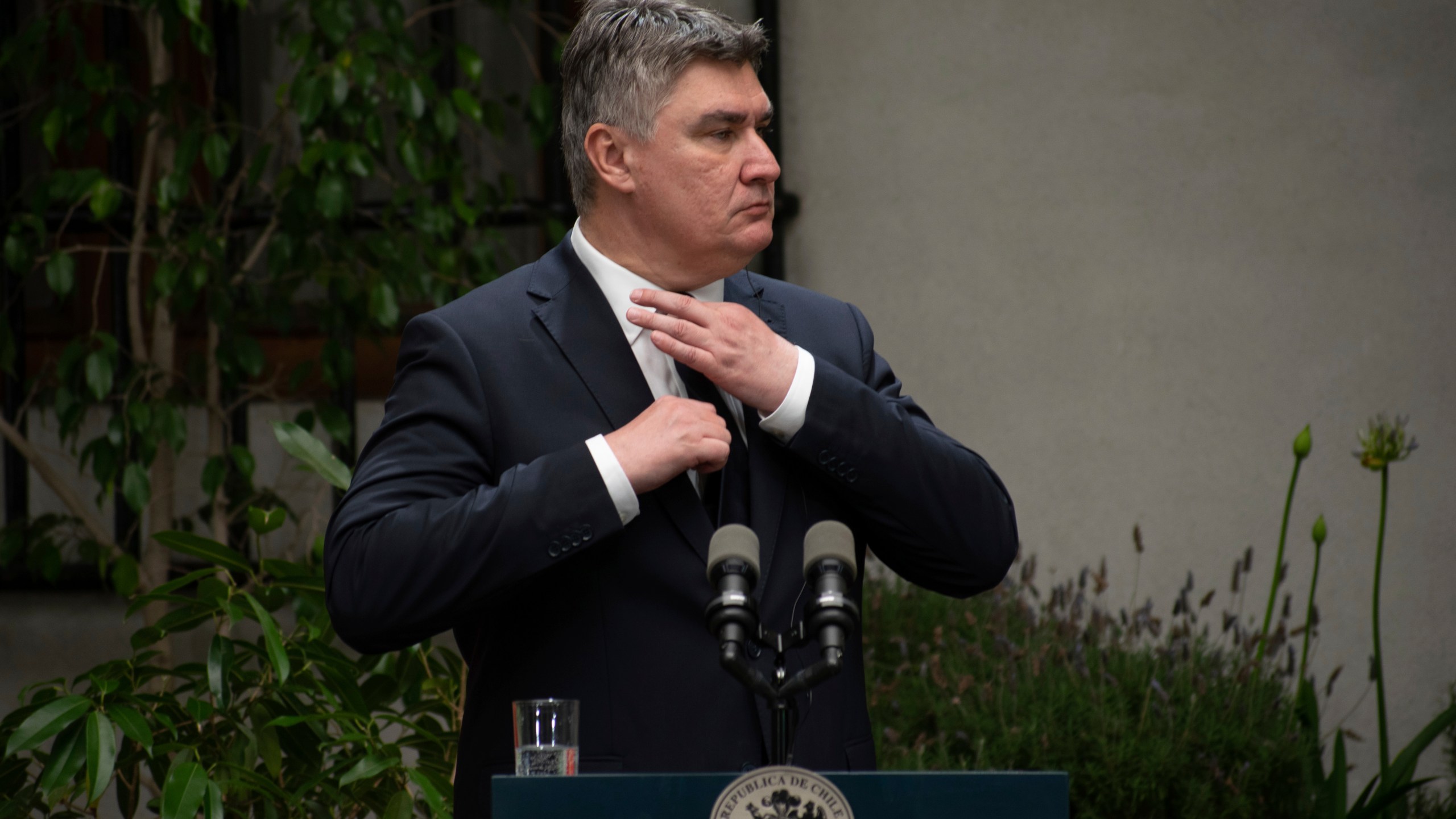 FILE - Croatia's President Zoran Milanovic adjusts his tie at a press conference with Chilean President Gabriel Boric at La Moneda Presidential palace in Santiago, Chile, on Dec. 12, 2022. Milanovic cannot run for prime minister nor take part in the upcoming parliamentary election nor campaign in favor of an opposition party unless he resigns immediately from the current post, the state’s constitutional court ruled Monday, March 18, 2024. (AP Photo/Matias Basualdo, File)