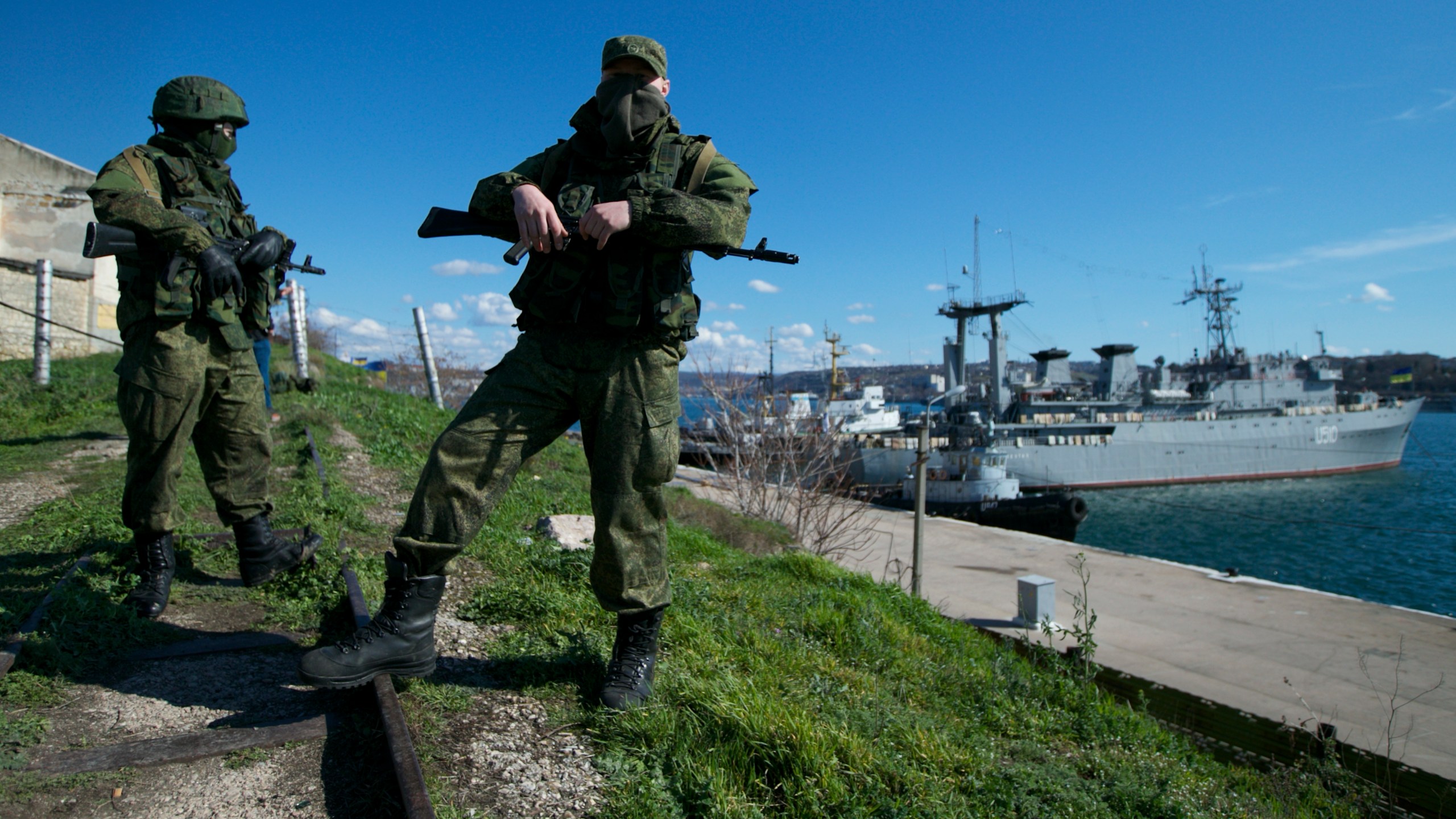 FILE - Russian soldiers guard a pier where two Ukrainian naval vessels are moored, in Sevastopol, Ukraine, on Wednesday, March 5, 2014. When Ukraine's Kremlin-friendly president was ousted in 2014 by mass protests that Moscow called a U.S.-instigated coup, Russian President Vladimir Putin responded by sending troops to overrun Crimea and staging a plebiscite on joining Russia, which the West dismissed as illegal. (AP Photo, File)