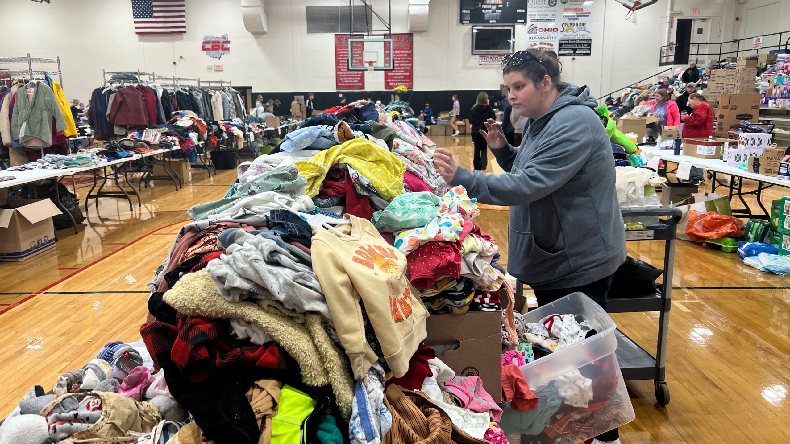 A woman searches through clothing at Indian Lake High School on Saturday, March 16, 2024, in Indian Lake, in Logan County, Ohio. The high school has become a donation center after a tornado swept through the Indian Lake area Thursday. The Indian Lake area in Ohio’s Logan County was one of the hardest hit. (AP Photo/Patrick Orsagos)