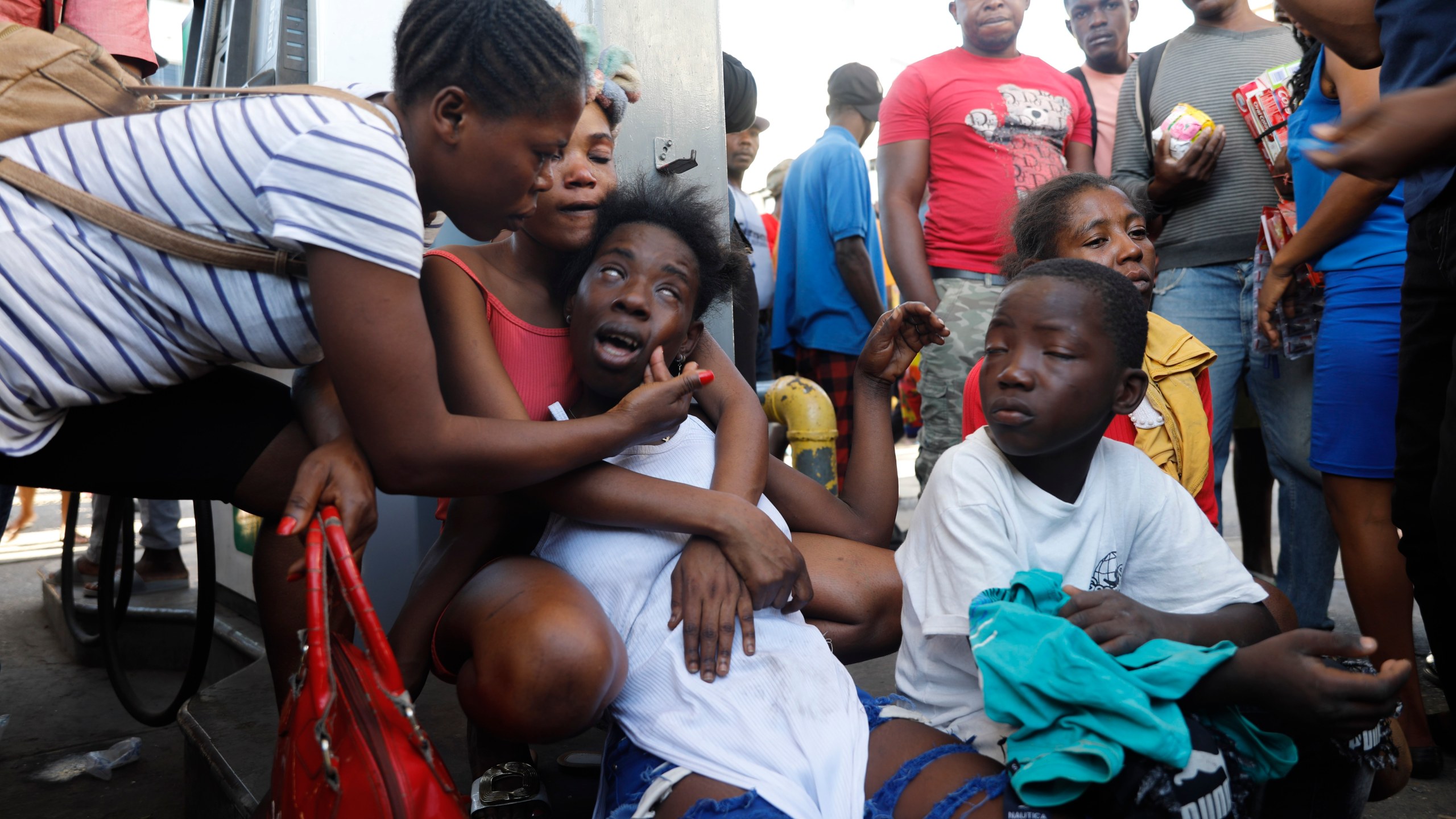 The relative of a person found dead in the street reacts after an overnight shooting in the Petion Ville neighborhood of Port-au-Prince, Haiti, Monday, March 18, 2024. (AP Photo/Odelyn Joseph)