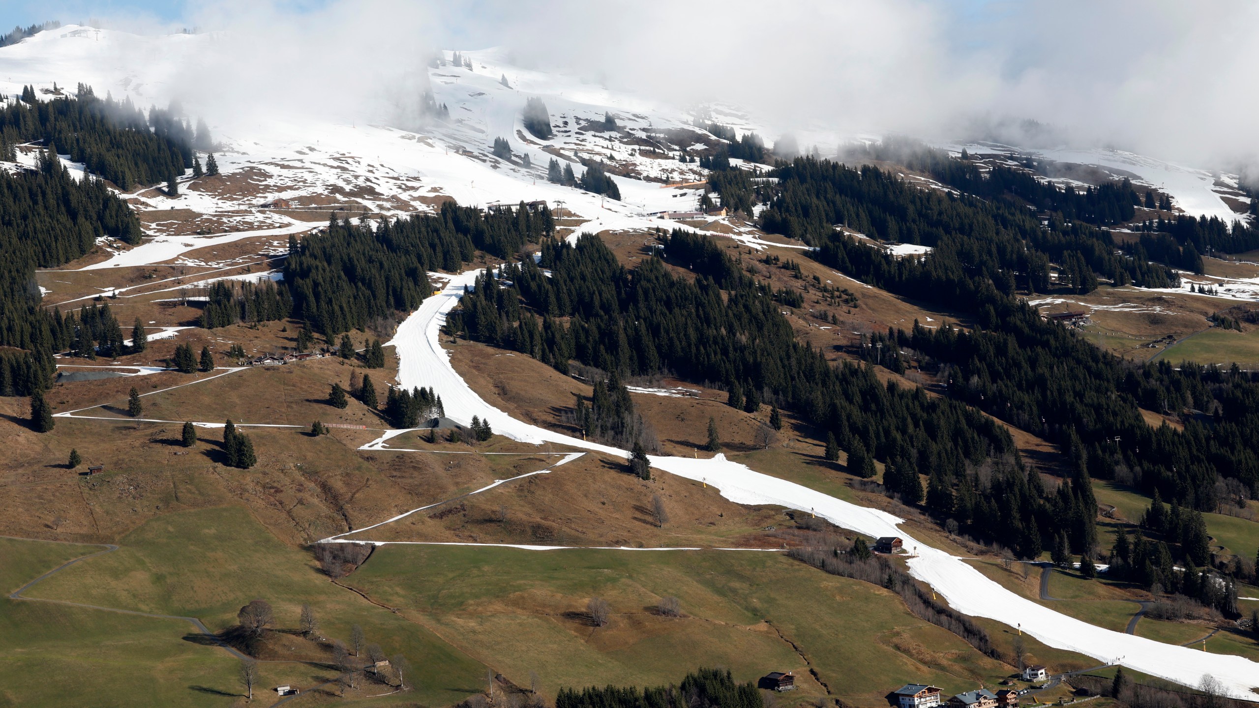 FILE - A strip of snow makes a ski slope in Saalbach, Austria, Sunday, March 17, 2024. The U.N. weather agency is sounding “a red alert” about global warming last year and beyond, citing in a new report record-smashing statistics when it comes to greenhouse gases, temperatures of land and oceans, and melting glaciers and sea-ice — even if countries, companies and citizens are getting greener. (AP Photo/Alessandro Trovati, File)