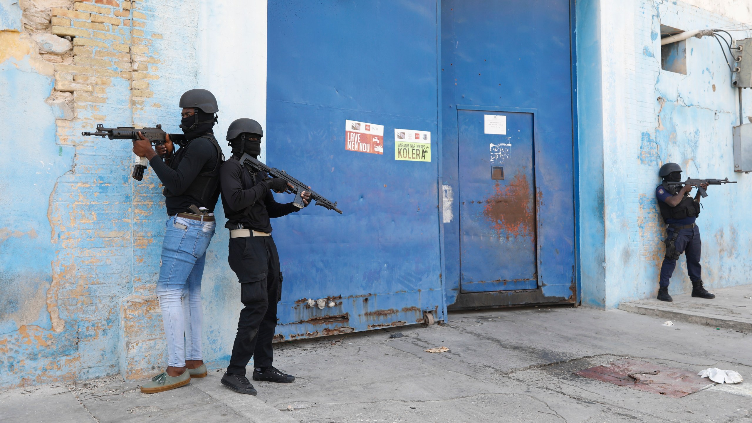 Agentes de la Policía Nacional vigilan el exterior de la Penitenciaría Nacional, ya vacía tras una fuga de reos, luego que se registrara un pequeño incendio en las instalaciones, en el centro de Puerto Príncipe, Haití, el jueves 14 de marzo de 2024. (AP Foto/Odelyn Joseph)