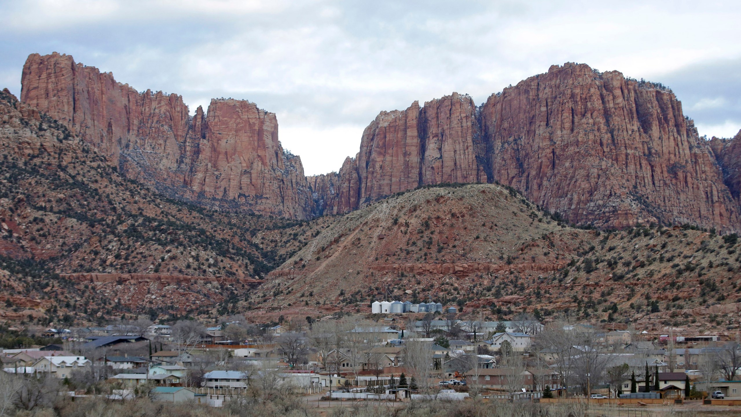 FILE - Hildale, Utah, is pictured sitting at the base of Red Rock Cliff mountains, with its sister city, Colorado City, Ariz., in the foreground on Dec. 16, 2014. On Tuesday, March 19, 2024, a businessman pleaded guilty to conspiring with the leader of an offshoot polygamous sect in the Colorado City-Hildale area to transport underage girls across state lines for sexual activity. The guilty plea by 53-year-old Moroni Johnson marked the first man to be convicted in what authorities say was a scheme to orchestrate sexual acts involving children. (AP Photo/Rick Bowmer, File)