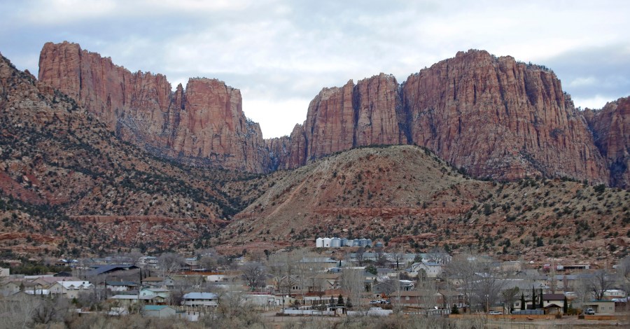 FILE - Hildale, Utah, is pictured sitting at the base of Red Rock Cliff mountains, with its sister city, Colorado City, Ariz., in the foreground on Dec. 16, 2014. On Tuesday, March 19, 2024, a businessman pleaded guilty to conspiring with the leader of an offshoot polygamous sect in the Colorado City-Hildale area to transport underage girls across state lines for sexual activity. The guilty plea by 53-year-old Moroni Johnson marked the first man to be convicted in what authorities say was a scheme to orchestrate sexual acts involving children. (AP Photo/Rick Bowmer, File)