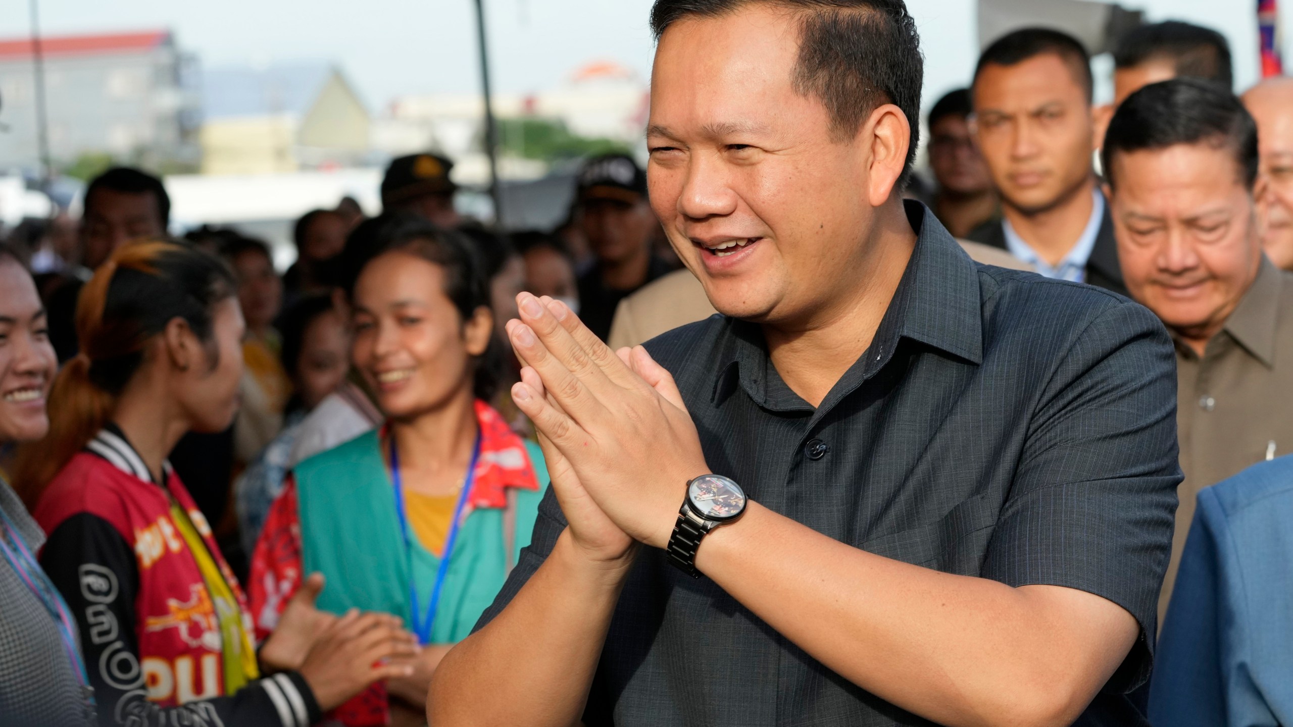 FILE - Cambodian Prime Minister Hun Manet greets garment workers at Prey Speu village outside Phnom Penh, Cambodia, on Aug. 29, 2023. Manet has ordered a ban on musical horns, after videos posted on social media showed people dancing on roads and roadsides as passing trucks blasted rhythmic little tunes. Hun Manet called on the Ministry of Public Works and Transportation and police to immediately take action against any vehicle whose normal horn has been replaced by a tune-playing one by ripping it out and restoring the standard honking type. (AP Photo/Heng Sinith, File)