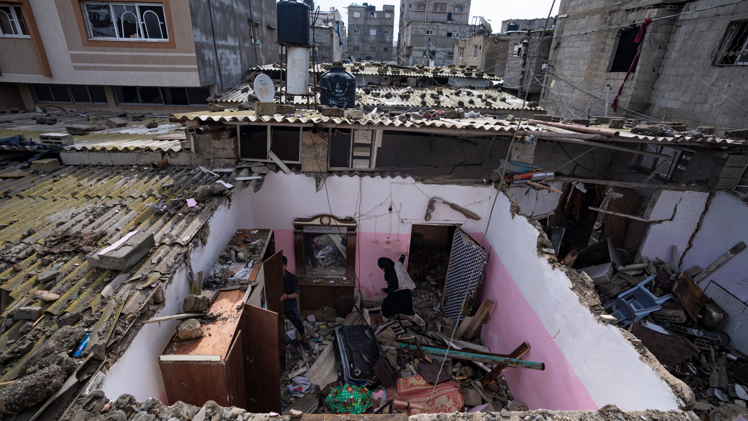 Palestinians inspect the damage to a house after an Israeli airstrike in Rafah, southern Gaza Strip, Tuesday, March 19, 2024. (AP Photo/Fatima Shbair)