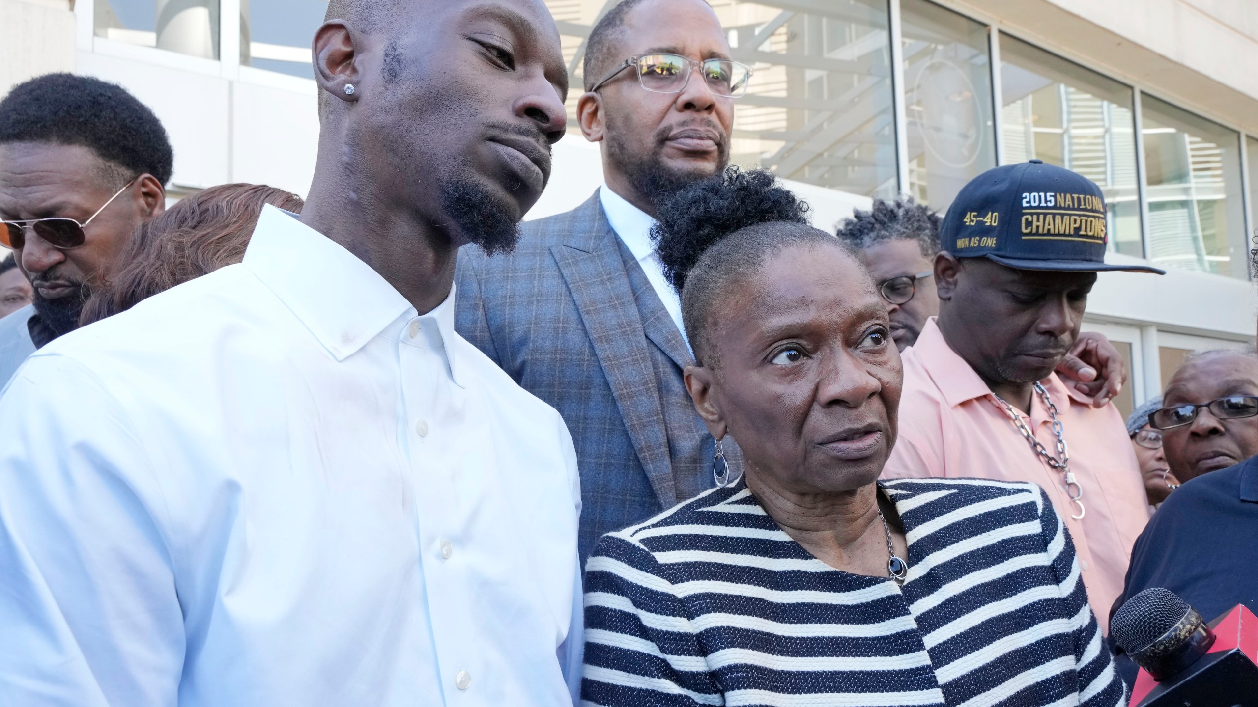 Michael Corey Jenkins, left, stands with his mother Mary Jenkins, center, and his friend Eddie Terrell Parker, right outside the Thad Cochran United States Courthouse in Jackson, Miss., Tuesday, March 19, 2024, following the 20-year sentence one of the six former Mississippi Rankin County law enforcement officers who committed numerous acts of racially motivated, violent torture on the two men in 2023, received. Sentencing continues Tuesday afternoon for the other five former law men in federal court. (AP Photo/Rogelio V. Solis)
