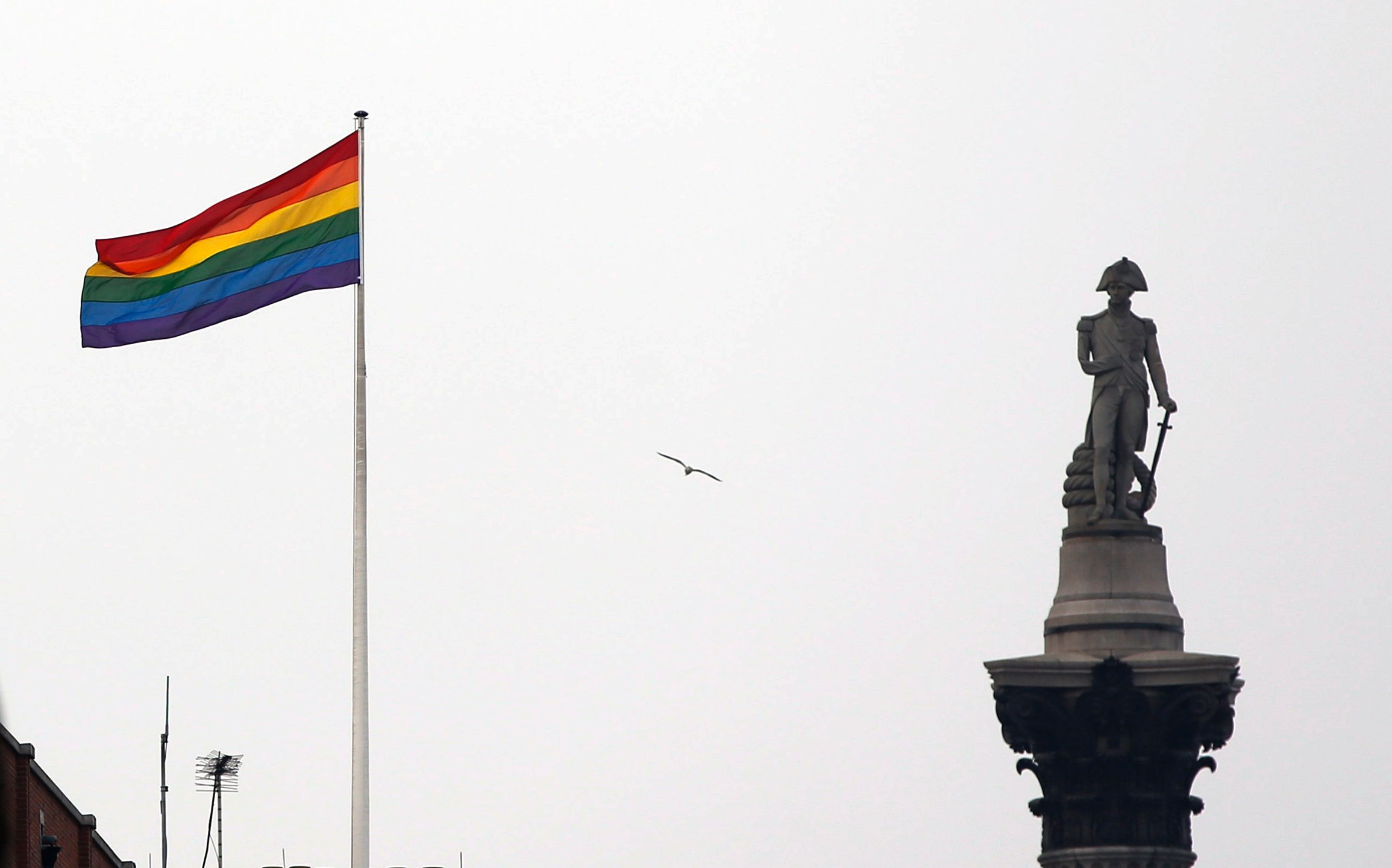 FILE - The rainbow flag, a symbol of the LGBTQ+ community, flies over a building next to Nelson's Column monument, right, in Trafalgar Square, central London, Britain, March 28, 2014. Legislators in at least two U.S. states are citing England’s recent decision to severely restrict gender transitions for young people as support for their own related bills. (AP Photo/Lefteris Pitarakis, File)