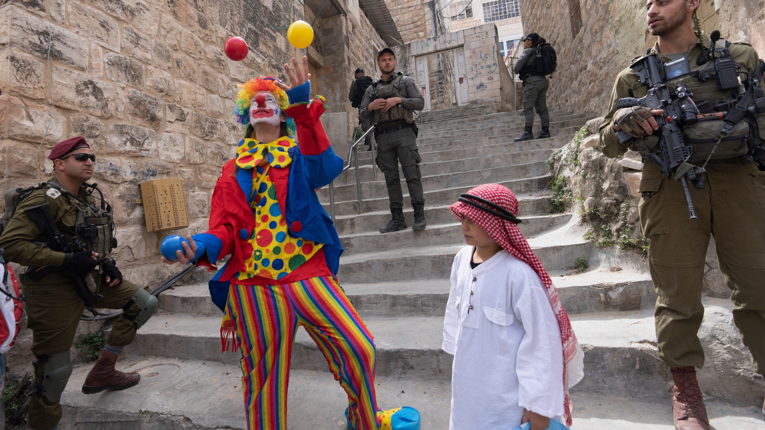 FILE - Jewish settlers dressed in costumes celebrate the Jewish holiday of Purim as soldiers secure the march in the West Bank city of Hebron, March 7, 2023. Purim celebrates the biblical story of how a plot to exterminate Jews in Persia was thwarted, and thus is embraced as an affirmation of Jewish survival throughout history. For many Jews, it will have extra significance in 2024 during a war in Gaza triggered by the Oct. 7, 2023, attacks on Israel in which Hamas killed 1,200 people and took about 250 others hostage. (AP Photo/Ohad Zwigenberg, File)