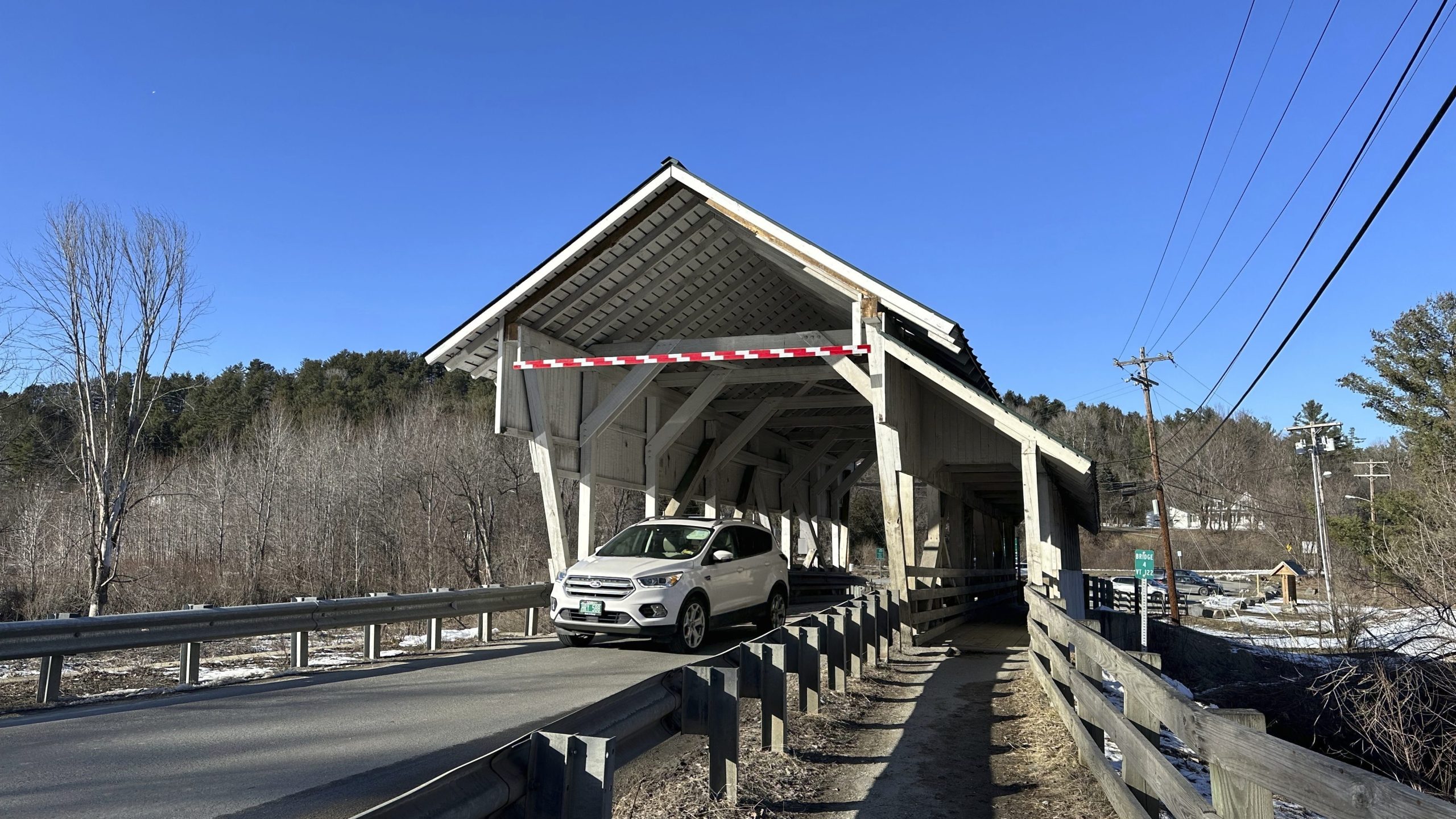 A vehicle passes through the Miller's Run covered bridge in Lyndon, Vt., on Tuesday, March 12, 2024. The historic bridge is under threat from truck drivers relying on GPS meant for cars continually hitting the bridge. (AP Photo/Lisa Rathke)
