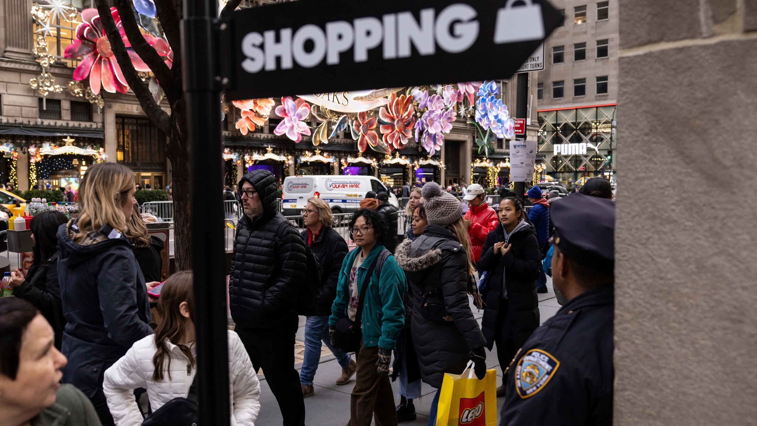 FILE - Shoppers and sightseers walk along 5th Avenue, Dec. 11, 2023, in New York. The National Retail Federation said Wednesday, March 20, 2024, that retail sales will increase anywhere between 2.5% and 3.5% this year, a solid but still slower pace than the 3.6% seen last year. (AP Photo/Yuki Iwamura, File)