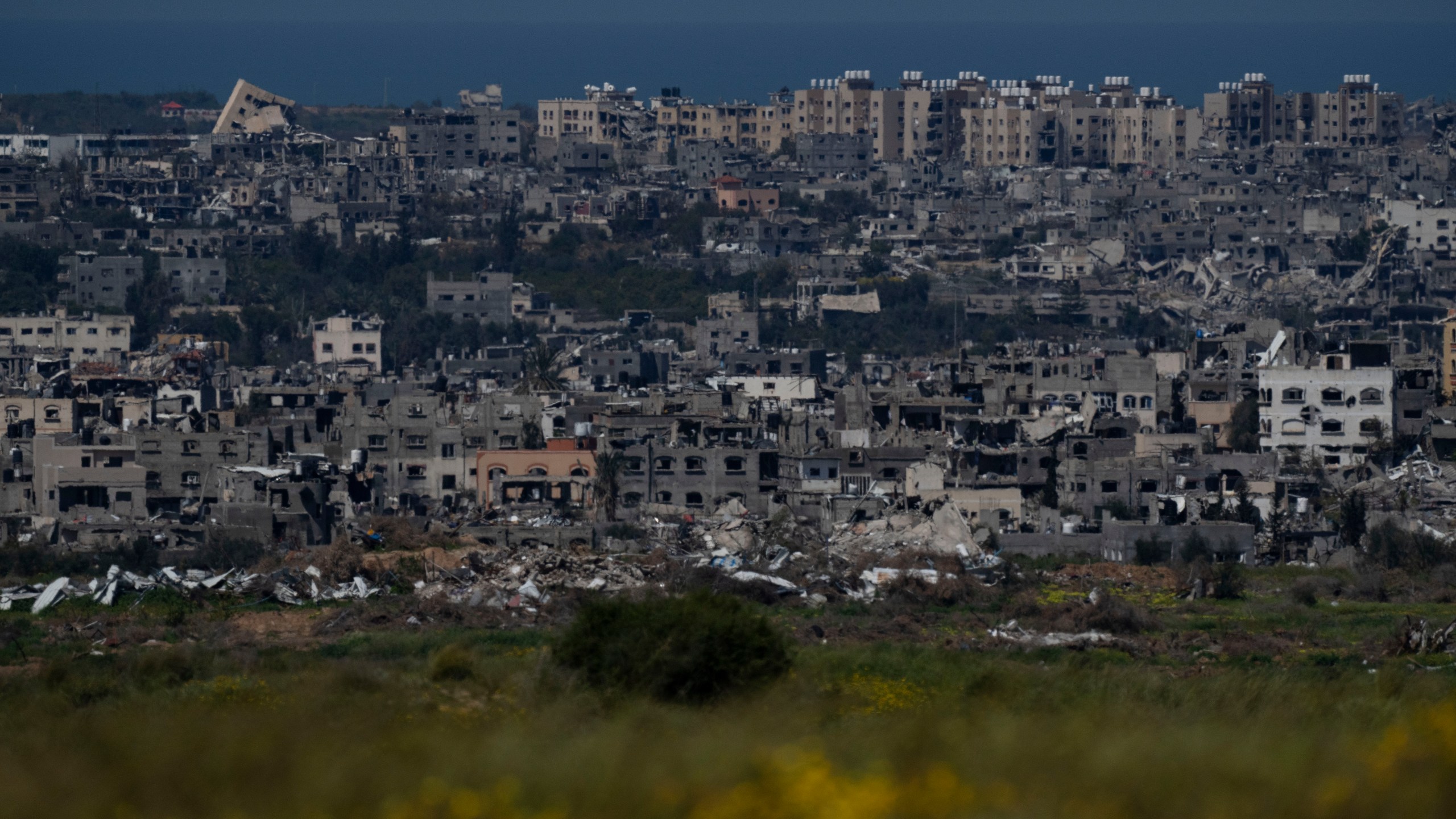 Destroyed buildings stand in the Gaza Strip, as seen from southern Israel, Wednesday, March 20, 2024. (AP Photo/Leo Correa)