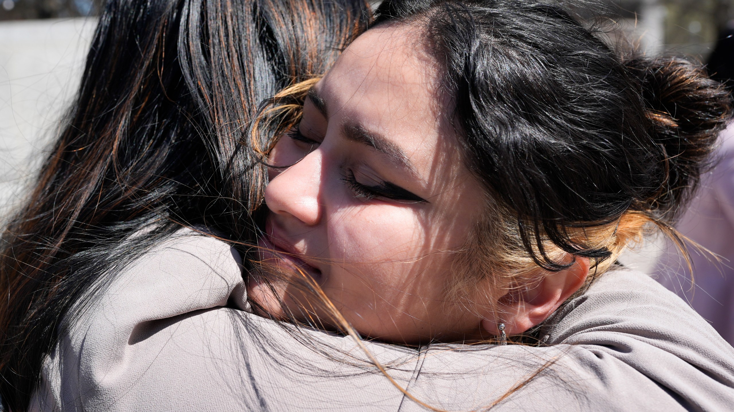 Joanna Maldonado, right, receives a hug after speaking during a news conference of the Tennessee Immigrant and Refugee Rights Coalition outside the state Capitol, Tuesday, March 19, 2024, in Nashville, Tenn. Members of the group came to the state Capitol to lobby legislators to vote against legislation that require local law-enforcement agencies to operate as if they have federal 287(g) agreements and a bill criminalizing transportation of undocumented immigrants. (AP Photo/George Walker IV)