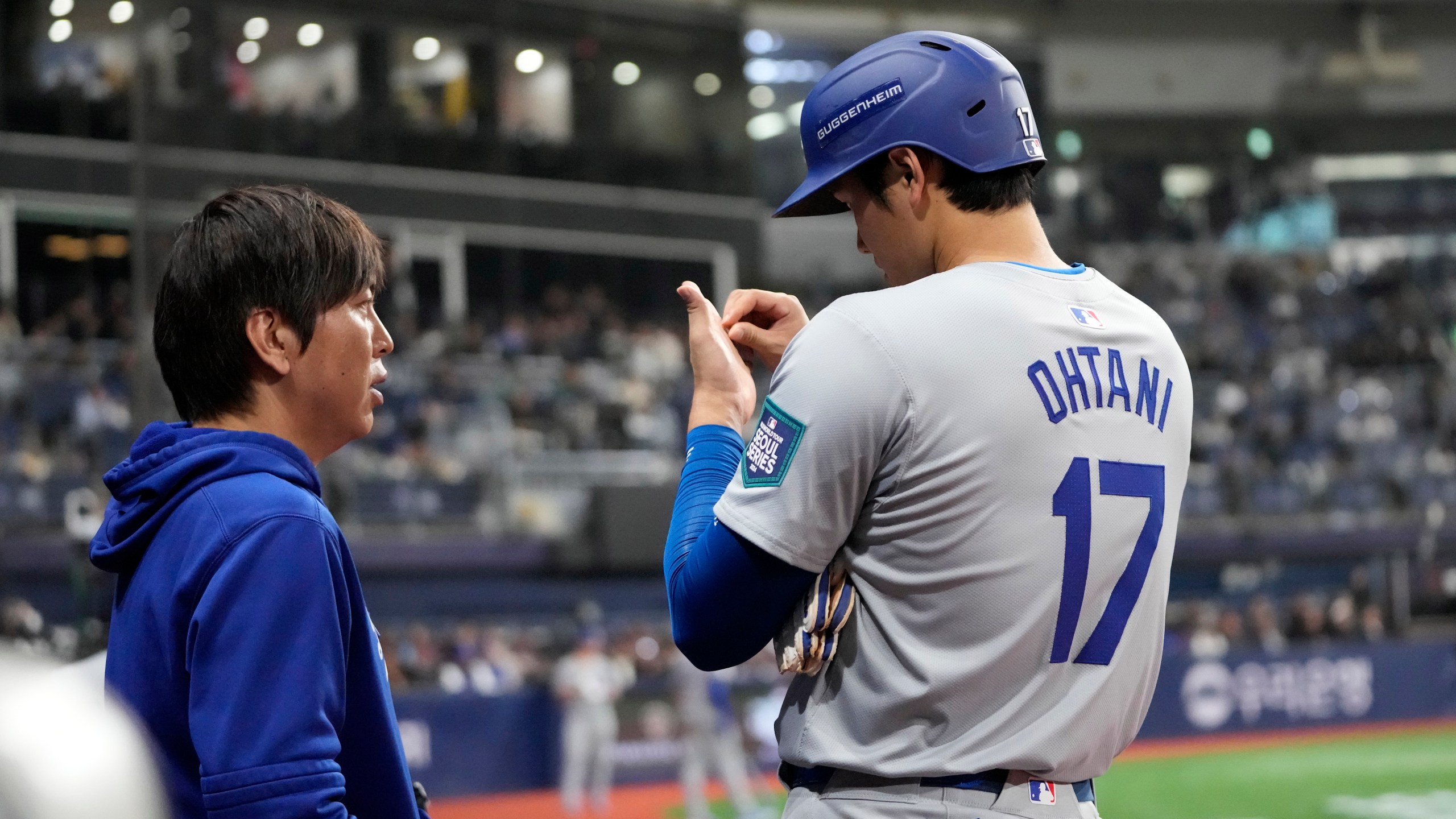 Los Angeles Dodgers designated hitter Shohei Ohtani, right, talks to his interpreter Ippei Mizuhara during the fifth inning of an opening day baseball game against the San Diego Padres at the Gocheok Sky Dome in Seoul, South Korea Wednesday, March 20, 2024, in Seoul, South Korea. (AP Photo/Lee Jin-man)