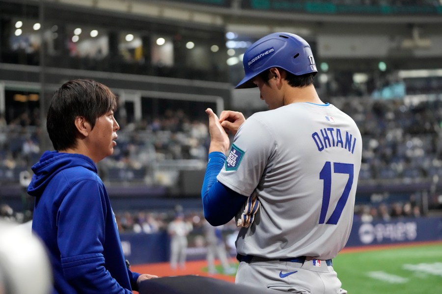 Los Angeles Dodgers designated hitter Shohei Ohtani, right, talks to his interpreter Ippei Mizuhara during the fifth inning of an opening day baseball game against the San Diego Padres at the Gocheok Sky Dome in Seoul, South Korea Wednesday, March 20, 2024, in Seoul, South Korea. (AP Photo/Lee Jin-man)