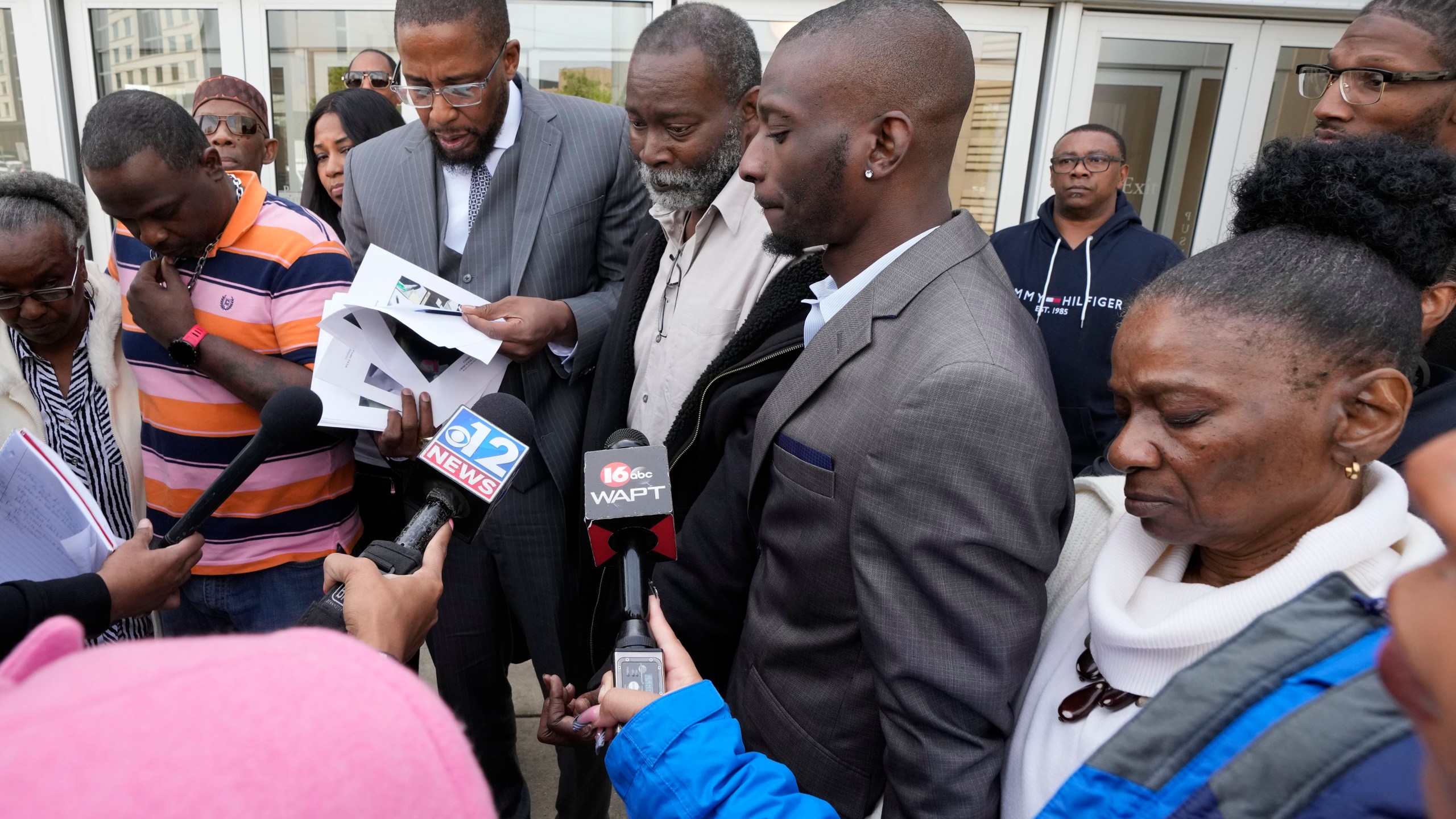 Lead civil attorney Malik Shabazz, second from left, speaks to reporters while his clients, Eddie Terrell Parker, left, Michael Corey Jenkins, and his father Melvin Jenkins, center, and mother Mary Jenkins, right, listen while outside the federal courthouse in Jackson, Miss., Wednesday, March 20, 2024, following the federal court sentencing of the third of six former Mississippi Rankin County law enforcement officers who committed numerous acts of racially motivated, violent torture on Parker and Jenkins in 2023. (AP Photo/Rogelio V. Solis)
