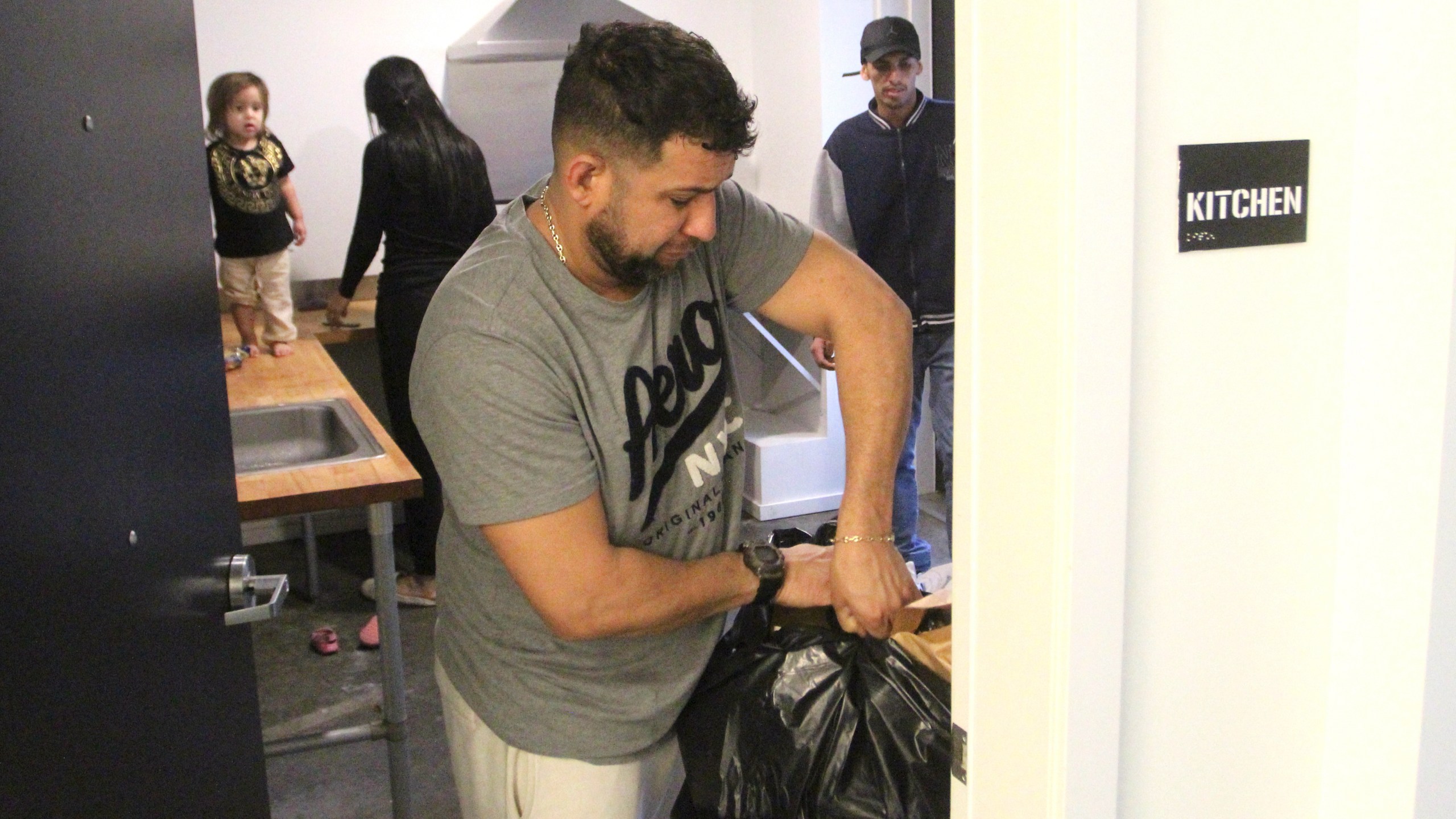 Javier Chirinos Mendoza takes out a garbage bag from the communal kitchen in a 'micro apartment' building in Seattle on Monday, March 11, 2024. (AP Photo/Manuel Valdes)
