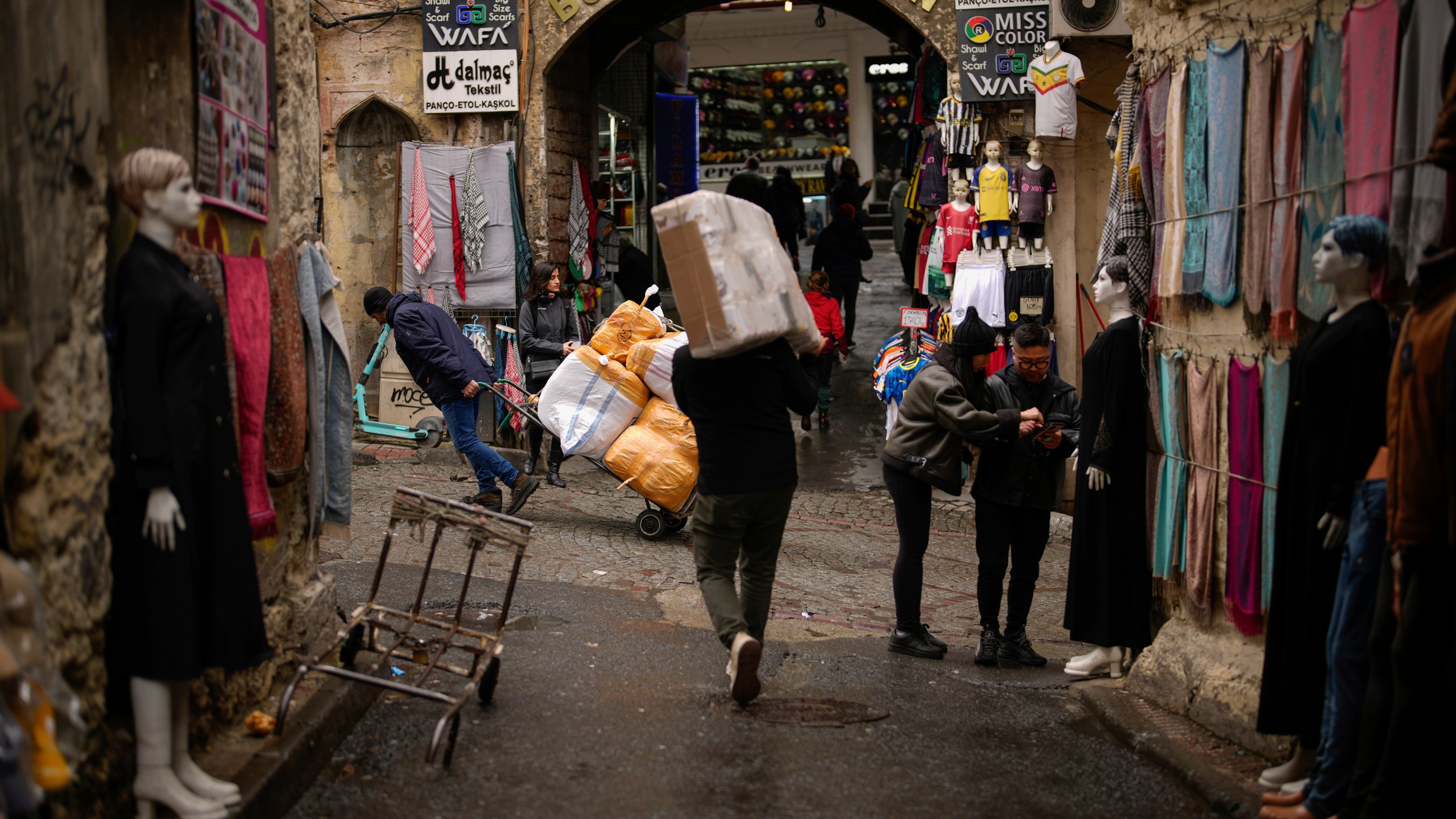 People carry goods in Eminonu trade neighbourhood in Istanbul, Turkey, Wednesday, March 20, 2024. Turkey's central bank raised its key interest rate by 5 percentage points on Thursday, resuming a policy of rate hikes aimed at combating soaring inflation that is causing households severe economic pain. (AP Photo/Emrah Gurel)