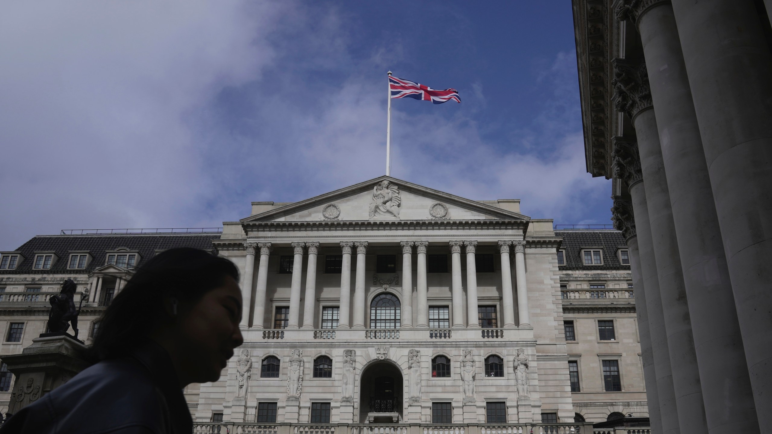 FILE - A woman walks in front of the Bank of England, at the financial district in London, on March 23, 2023. The Bank of England is widely expected to indicate Thursday March 21, 2024 that interest rates could be cut in the coming months following news that inflation across the U.K. is falling faster than expected. (AP Photo/Kin Cheung, File)