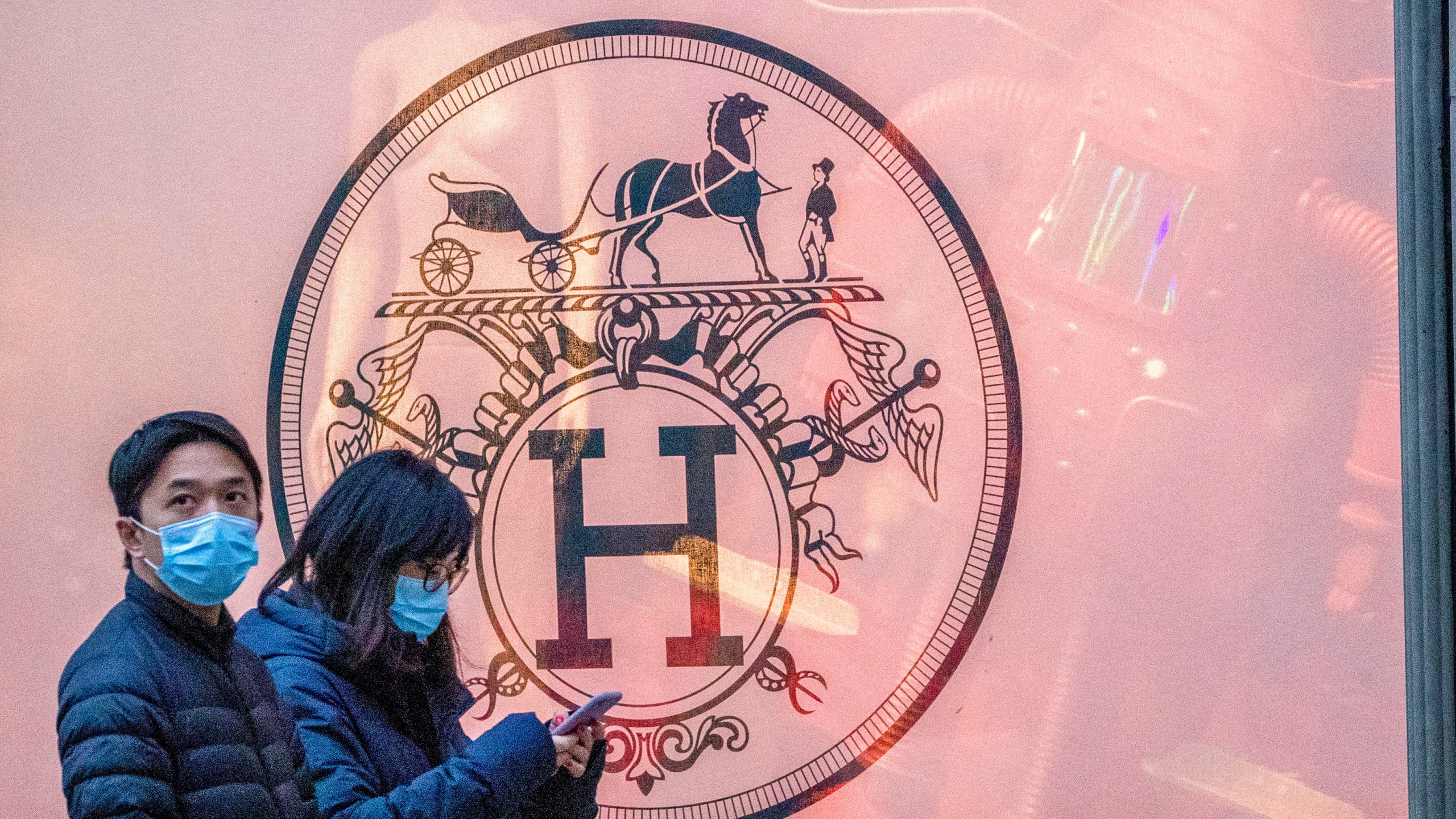 FILE - Pedestrians walk past the Hermes store on Madison Avenue, Thursday, March 19, 2020, in New York. Hermes, the maker of famed bags, is the target of a class action lawsuit, Thursday, March 21, 2024, that claims that the luxury retailer unlawfully prevents customers who have not spent enough at its stores from buying its coveted Birkin handbags. (AP Photo/Mary Altaffer, File)