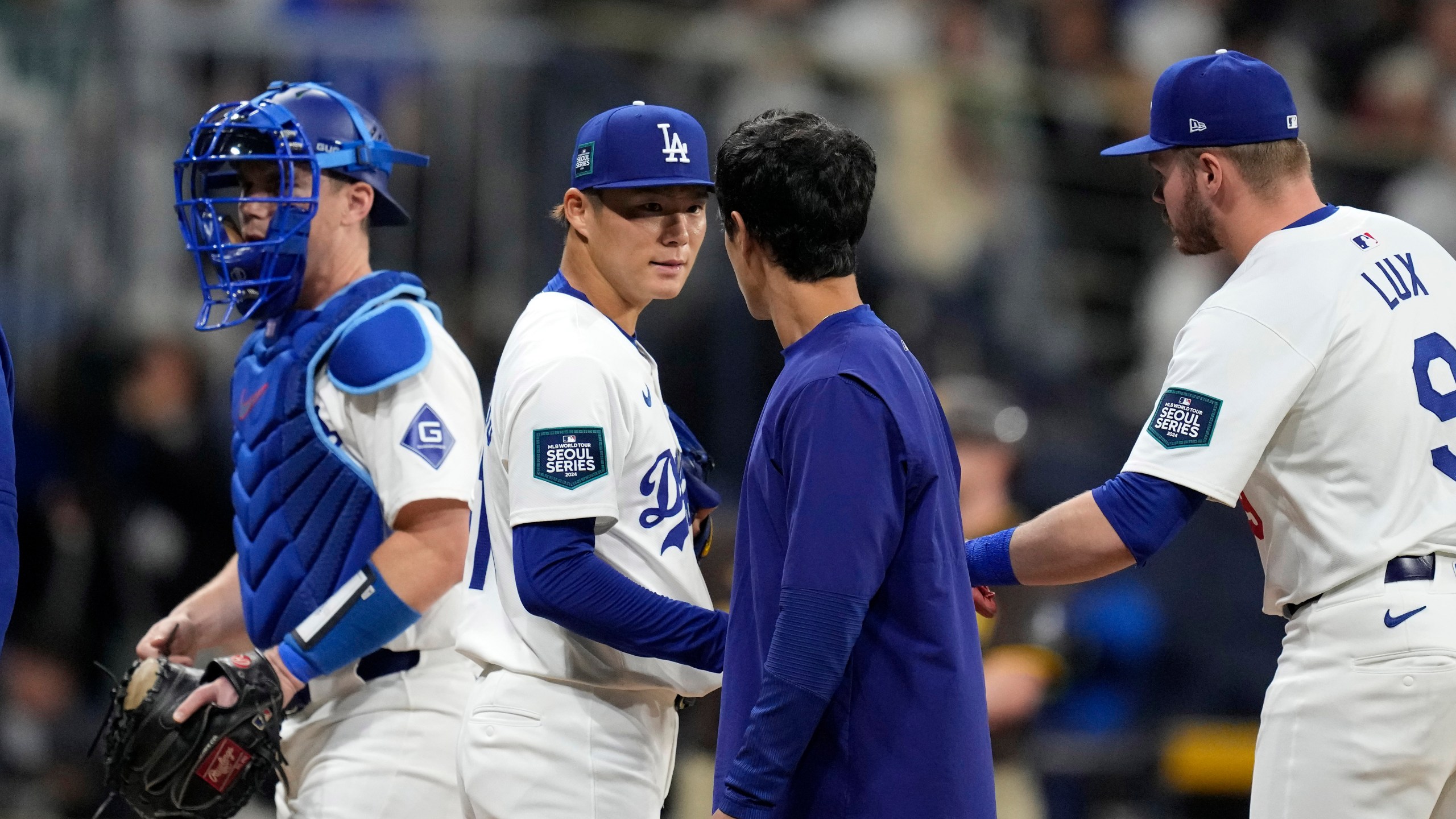 Los Angeles Dodgers starting pitcher Yoshinobu Yamamoto, second from left, speaks with interpreter Will Ireton, second from right, as catcher Will Smith, left, and second baseman Gavin Lux during the first inning of a baseball game at the Gocheok Sky Dome in Seoul, South Korea Thursday, March 21, 2024, in Seoul, South Korea. (AP Photo/Lee Jin-man)