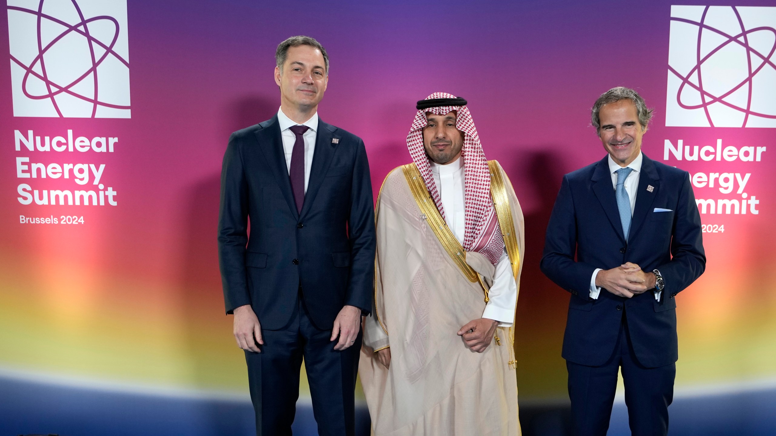 Belgium's Prime Minister Alexander De Croo, left, and Secretary General of the IAEA Rafael Mariano Grossi, right, welcome Saudi Arabia's CEO of King Abdullah during arrivals City for Atomic and Renewable Energy Prince Mamdooh Bin Saud Bin Thinyyan Bin Mohammed Al Saud during a Nuclear Energy Summit at the Expo in Brussels, Thursday, March 21, 2024. (AP Photo/Virginia Mayo)