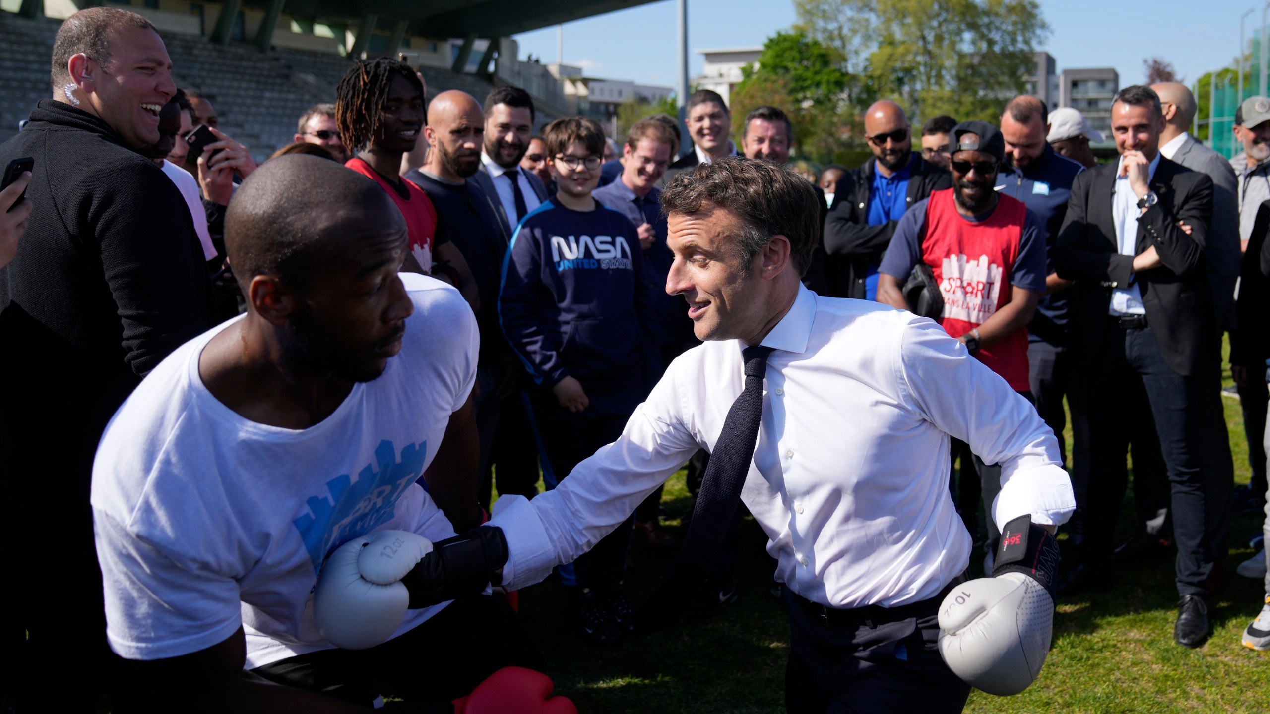 FILE - Centrist presidential candidate and French President Emmanuel Macron trains at boxing with amateur boxer Jean-Denis Nzaramba in the Auguste Delaune stadium as he campaigns in the Auguste Delaune stadium Thursday, April 21, 2022 in Saint-Denis, outside Paris. (AP Photo/Francois Mori, Pool, File)
