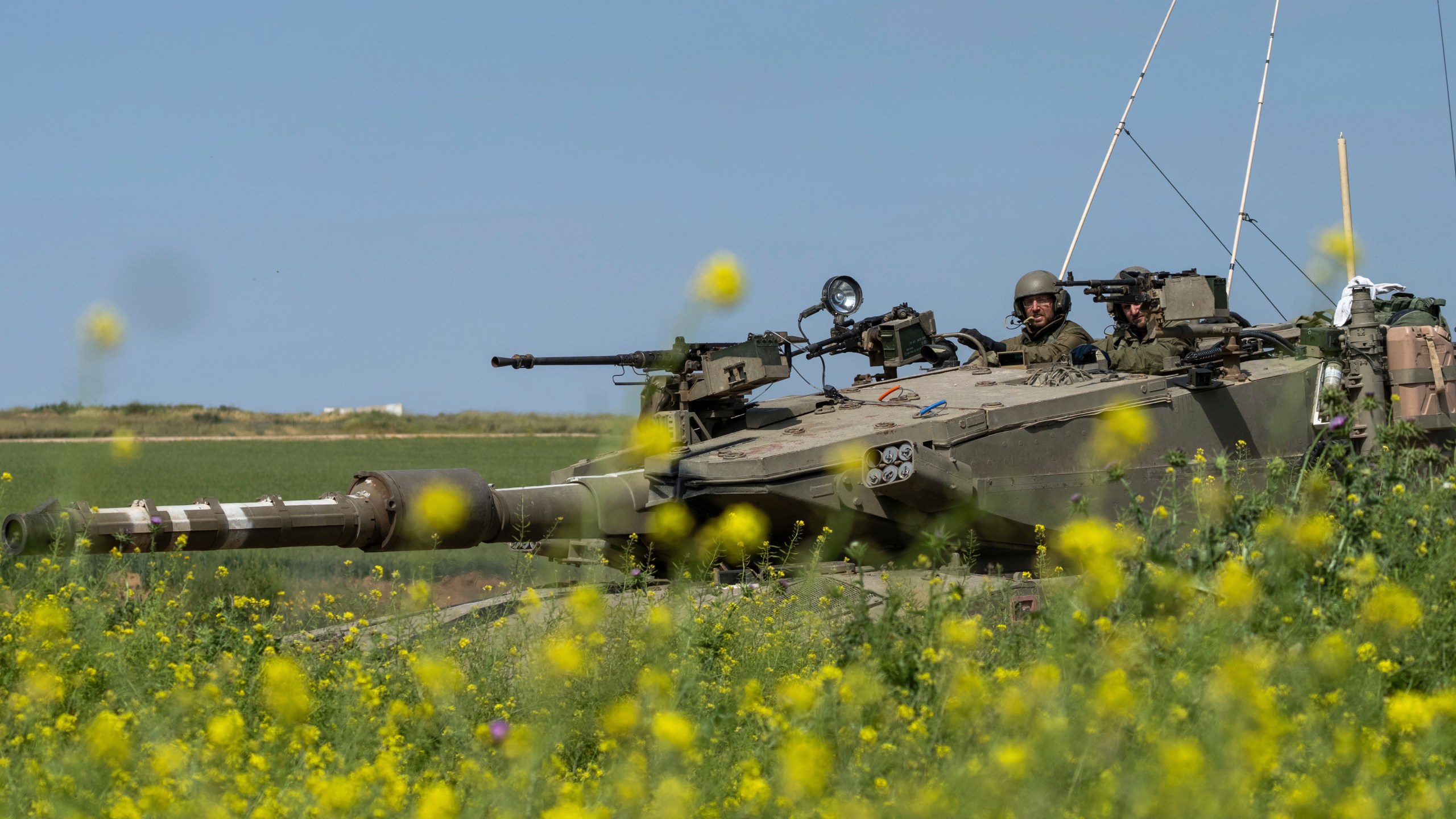 Israeli soldiers move on the top of a tank near the Israeli-Gaza border, as seen from southern Israel, Thursday, March 21, 2024. (AP Photo/Ohad Zwigenberg)