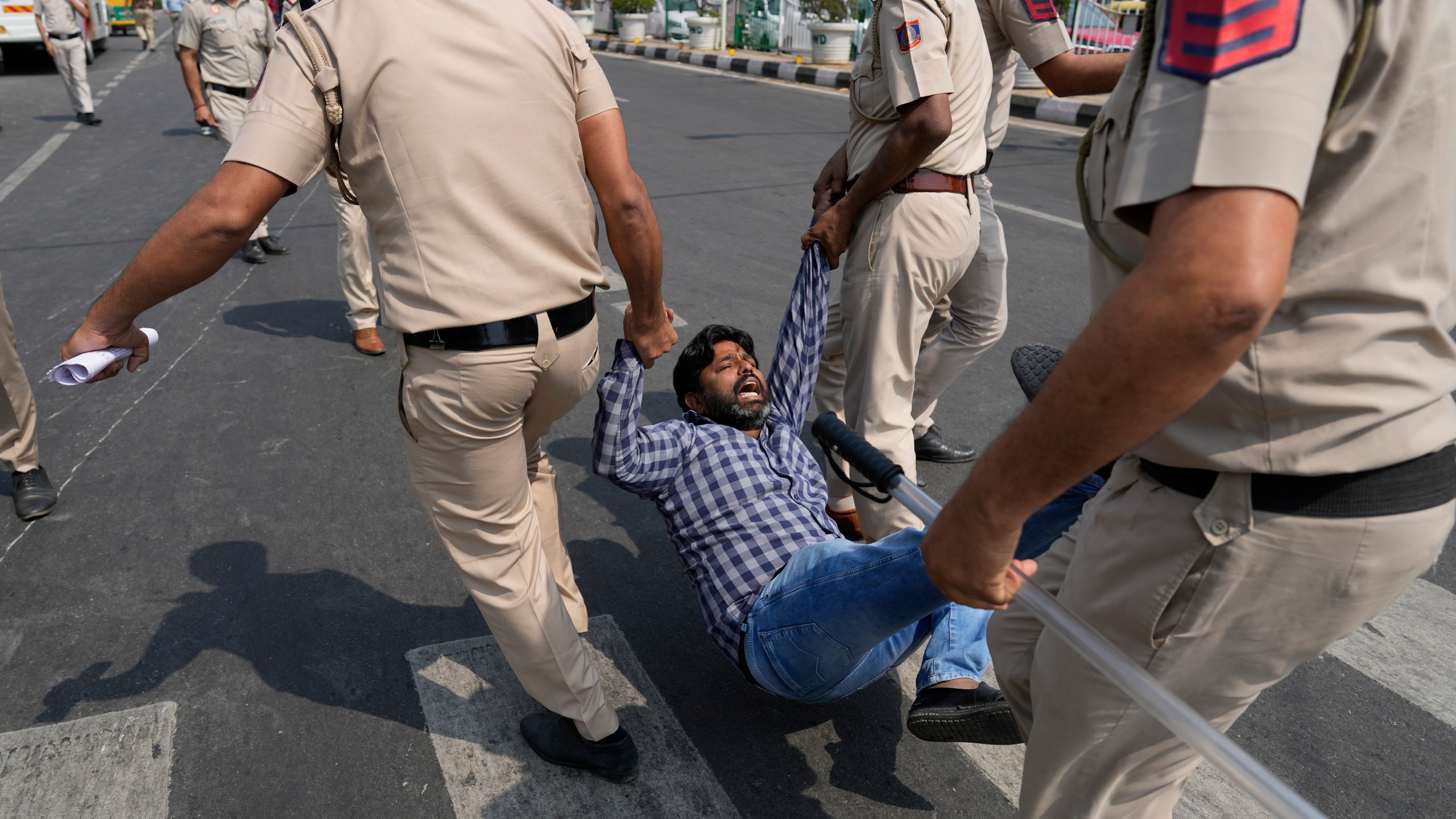 A supporter of Aam Admi Party, or Common Man's Party, is detained by the police officials during a protest against the arrest of their party leader Arvind Kejriwal, in New Delhi, India, Friday, March 22, 2024. Supporters of an anti-corruption crusader and one of India's most consequential politicians of the last decade in India held protests Friday against his arrest, which opposition parties say is part of a crackdown by Prime Minister Narendra Modi's government before national elections. (AP Photo/Manish Swarup)