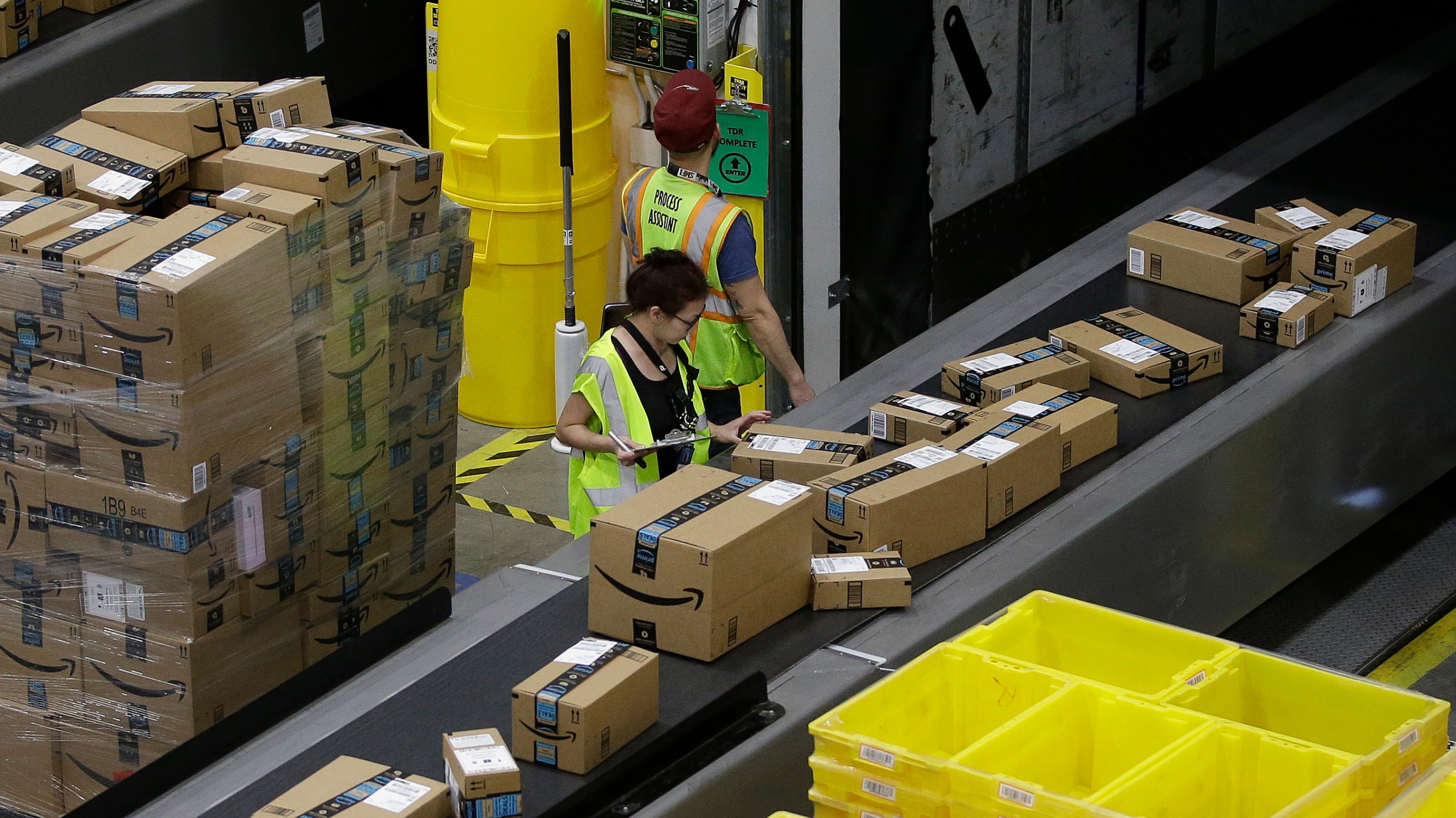 FILE - Packages move down a conveyor system were they are directed to the proper shipping area at an Amazon Fulfillment Center in Sacramento, Calif., on Feb. 9, 2018. As global warming rises temperatures, a California labor protection board has approved standards, Thursday, March 21, 2024, that would require companies protect their employees from excessive heat even inside, particularly in warehouses. The rules still need final approval by the state's Occupational Safety and Health Administration. (AP Photo/Rich Pedroncelli, File)