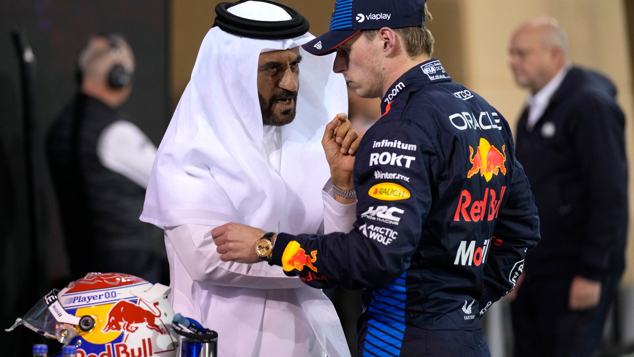 El piloto holandés de Red Bull Max Verstappen (centro) que ganó la clasificación conversa con el presidente de la FIA Mohammed Ben Sulayem, luego del clasificatorio de cara al Gran Premio de Baréin, en el circuito de Sakhir, Baréin, el viernes 1 de marzo de 2024. (AP Foto/Darko Bandic)