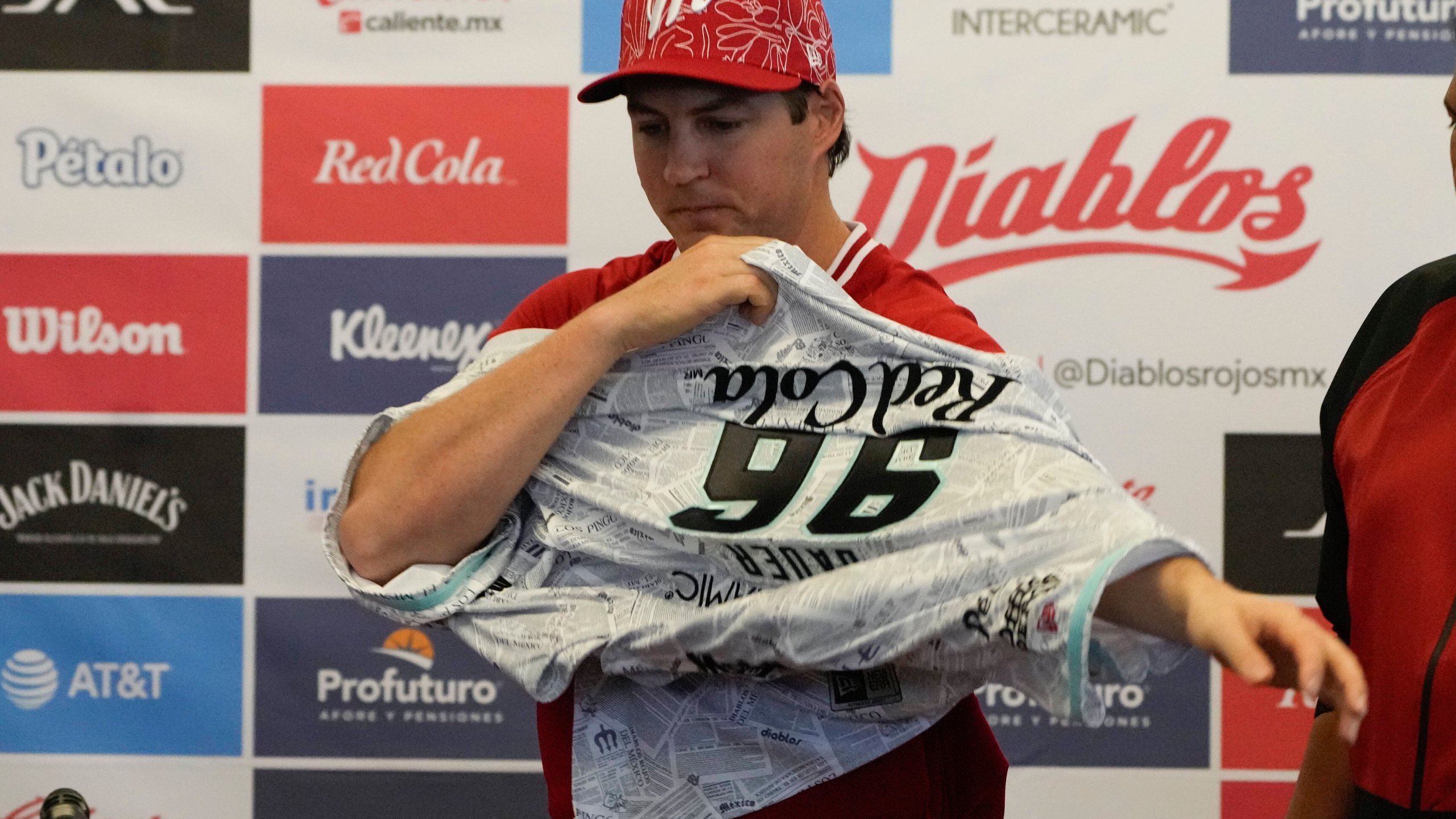 Trevor Bauer puts on his new uniform during his introduction ceremony as Diablos de Mexico's starting pitcher at Alfredo Harp Helú stadium in Mexico City, Friday, March 22, 2024. (AP Photo/Fernando Llano)