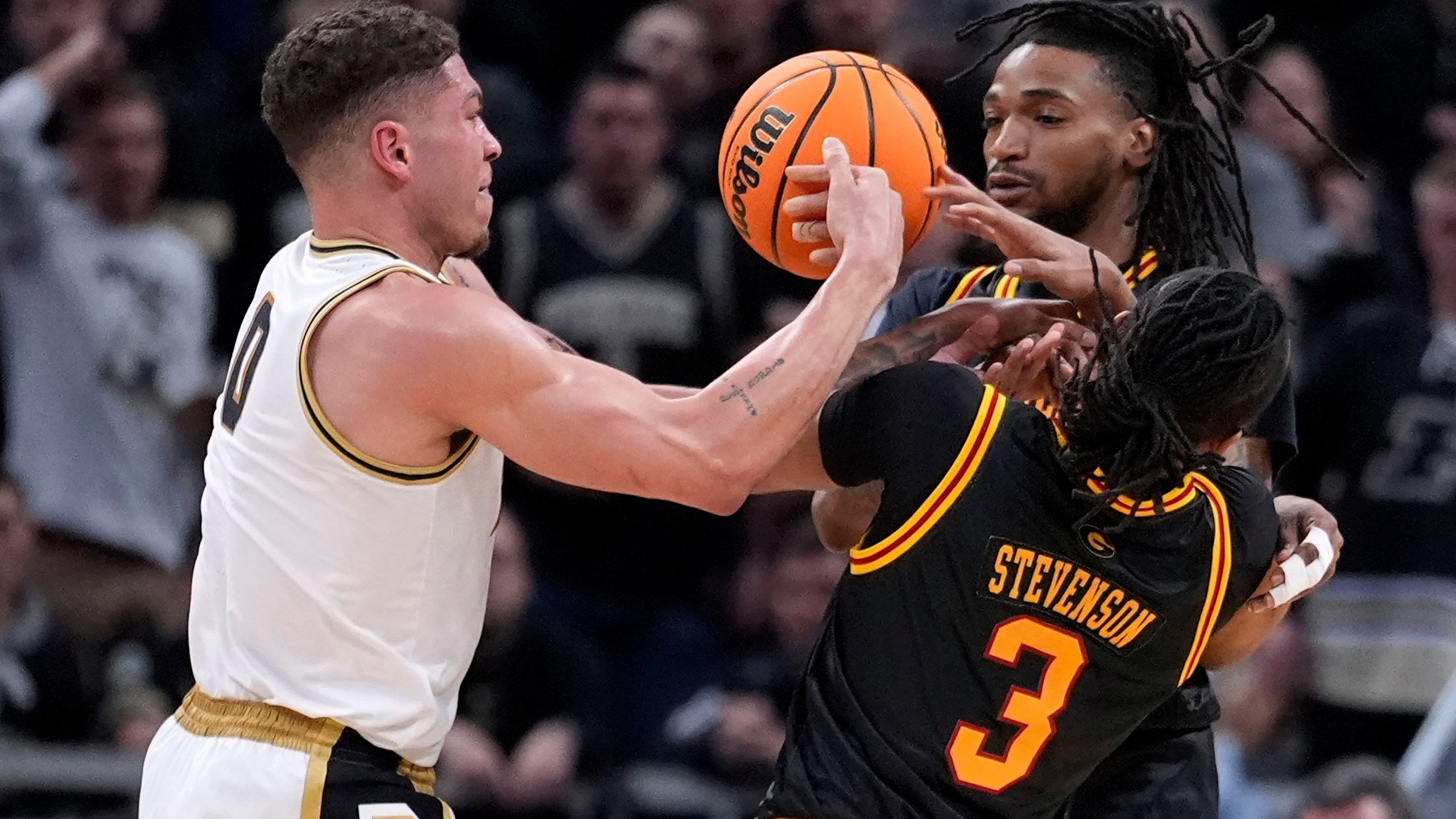 Purdue forward Mason Gillis, left, fights for a loose ball with Grambling State guard Mikale Stevenson (3) and guard Jourdan Smith, rear, in the first half of a first-round college basketball game in the NCAA Tournament, Friday, March 22, 2024, in Indianapolis. (AP Photo/Michael Conroy)