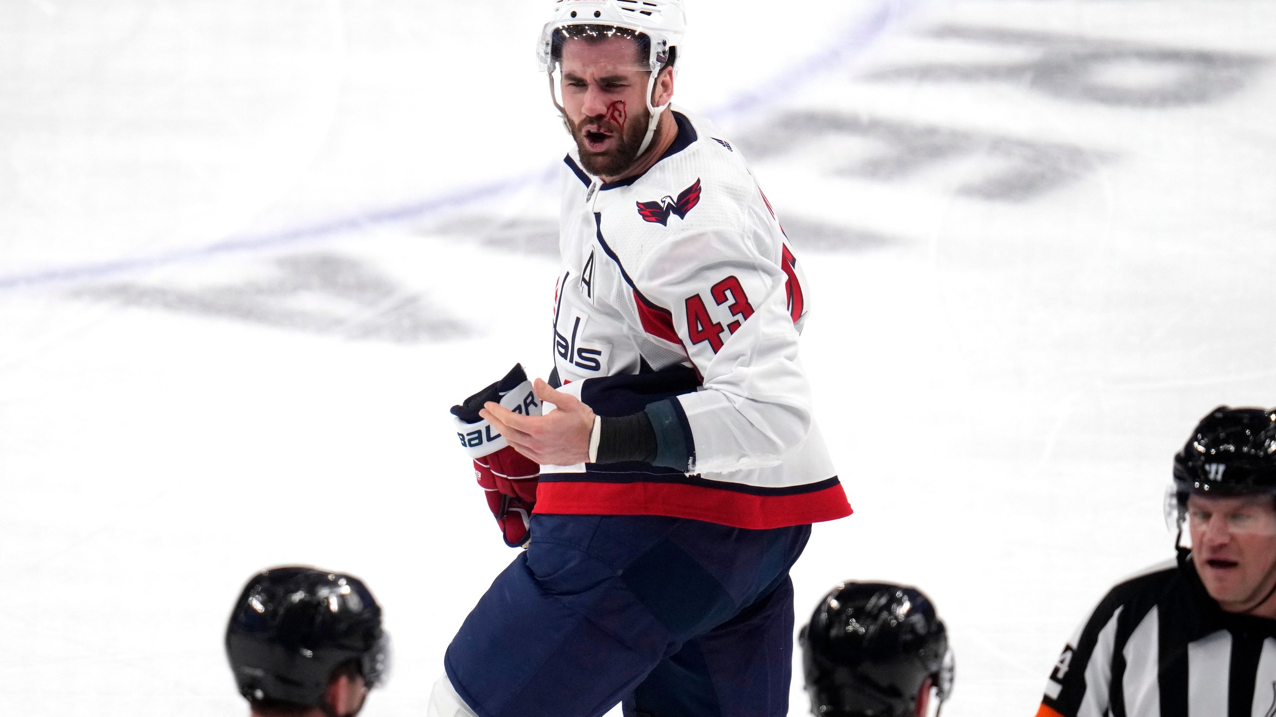 Washington Capitals' Tom Wilson (43) heads to the locker room after getting a high stick to the face from Pittsburgh Penguins' Ryan Graves during the first period of an NHL hockey game in Pittsburgh, Thursday, March 7, 2024. Wilson returned to the game later in the period. (AP Photo/Gene J. Puskar)