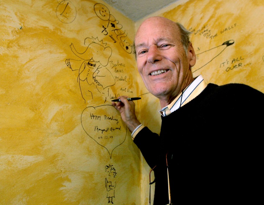 FILE - Babar author Laurent de Brunhoff signs the wall, while celebrating 75 years of the book on Friday, April 21, 2006 at Mabel's Fables in Toronto, Ont. De Brunhoff, a Paris native who moved to the U.S. in the 1980s, died Friday, March 22, 2024 at his home in Key West, Fla., according to The New York Times.(Nathan Denette /The Canadian Press via AP)