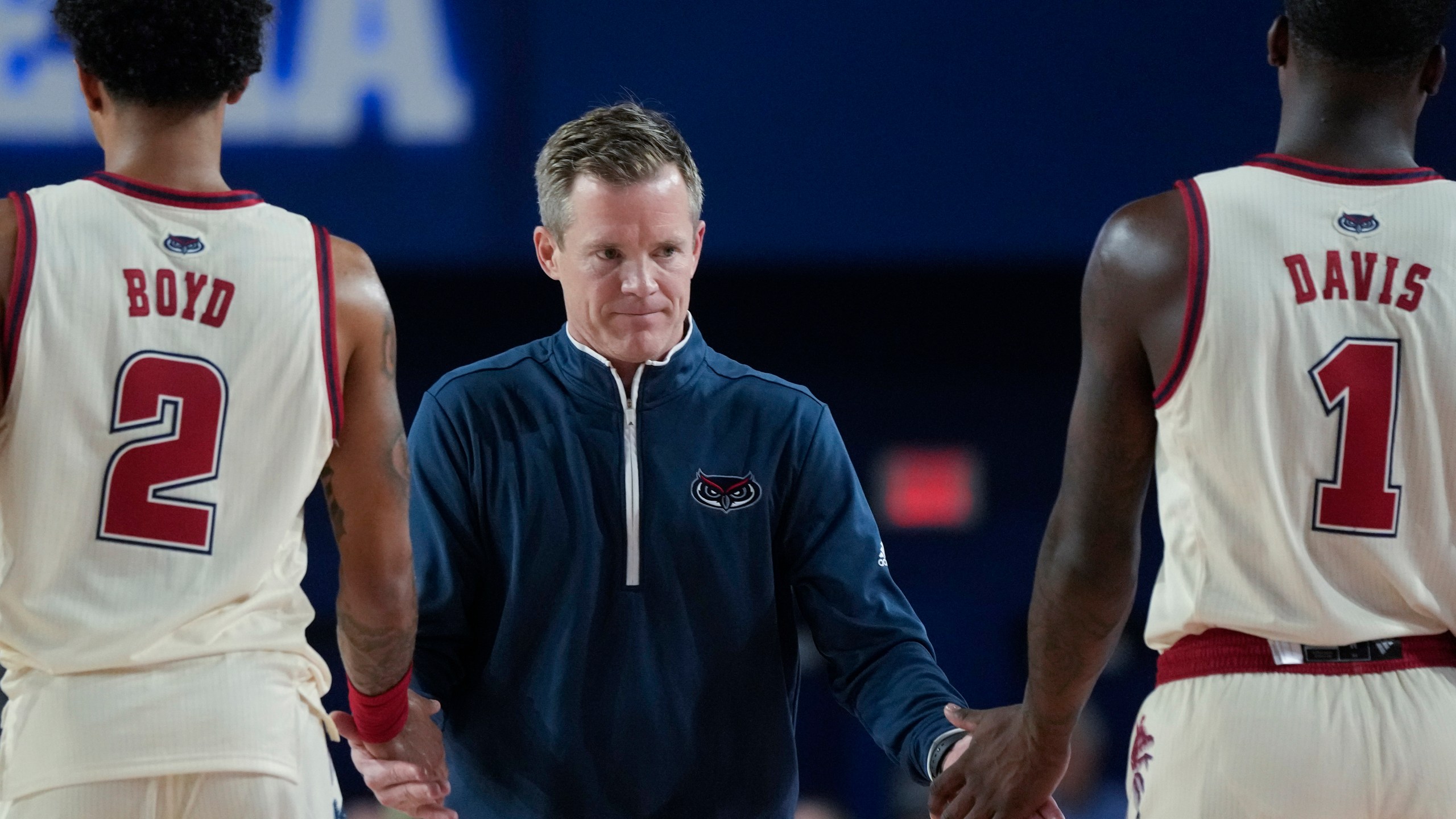 FILE - Florida Atlantic head coach Dusty May claps hands with guards Johnell Davis (1) and Nicholas Boyd (2) during the first half of an NCAA college basketball game, Nov. 14, 2023, in Boca Raton, Fla. May's hiring was announced Sunday, March 24, 2024 by Michigan, a move that brings him back to his Big Ten roots and ends his six-season stint that included a Final Four run a year ago at Florida Atlantic. (AP Photo/Rebecca Blackwell, file)