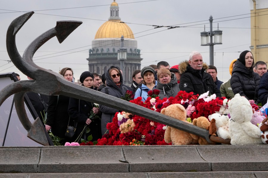 People lay flowers at a spontaneous memorial in memory of the victims of Moscow attack in St. Petersburg, Russia, Sunday, March 24, 2024. Russia observed a national day of mourning on Sunday, two days after an attack on a suburban Moscow concert hall that killed over 130 people. (AP Photo/Dmitri Lovetsky)