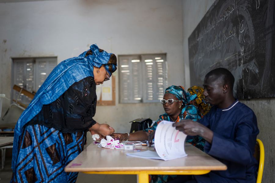 A woman dips his finger in ink after casting her vote inside a polling station during the presidential elections, in Dakar, Senegal, Sunday, March 24, 2024. (AP Photo/Mosa'ab Elshamy)