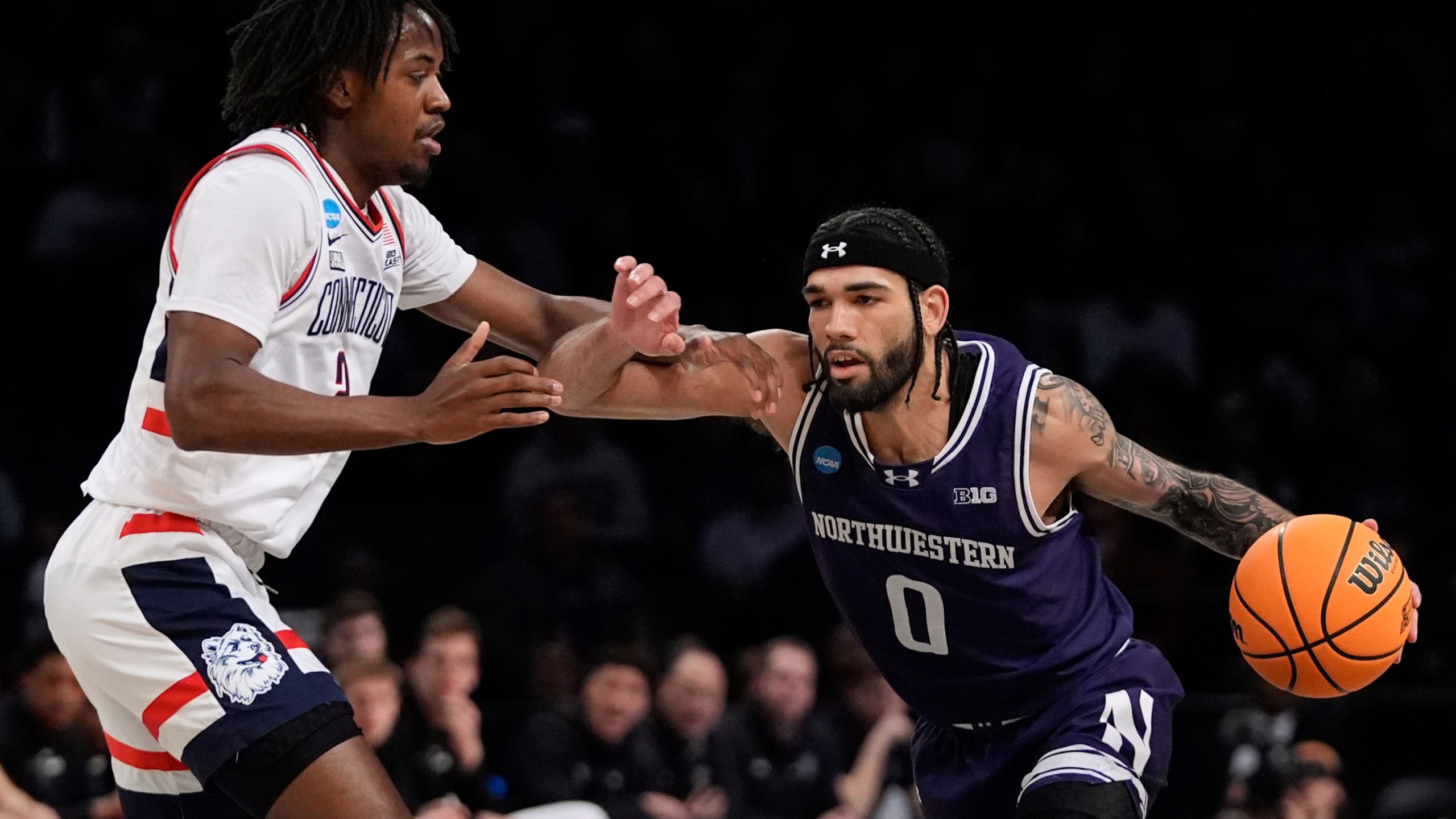 UConn's Tristen Newton, left, defends against Northwestern's Boo Buie during the first half of a second-round college basketball game in the NCAA Tournament Sunday, March 24, 2024, in New York. (AP Photo/Frank Franklin II)