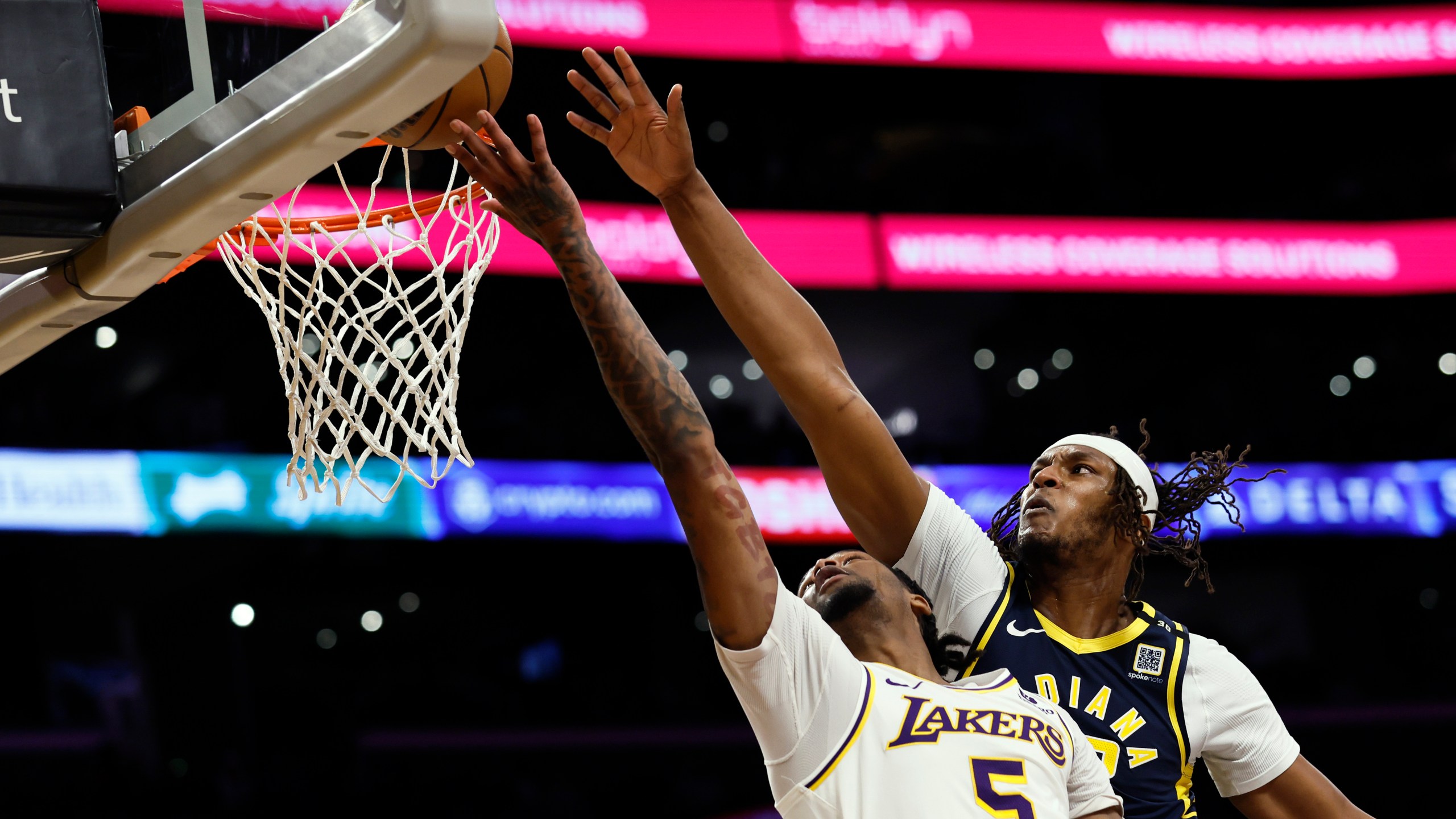 Los Angeles Lakers forward-guard Cam Reddish (5) is intercepted by Indiana Pacers center-forward Myles Turner, right, during the first half of an NBA basketball game, Sunday, March 24, 2024, in Los Angeles. (AP Photo/Etienne Laurent)