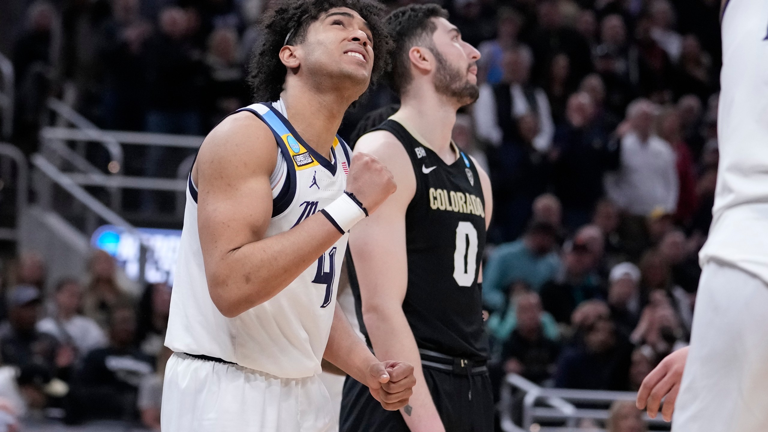 Marquette's Stevie Mitchell (4) celebrates alongside Colorado's Luke O'Brien following a second-round college basketball game in the NCAA Tournament, Sunday, March 24, 2024 in Indianapolis. Marquette won 81-77. (AP Photo/Michael Conroy)