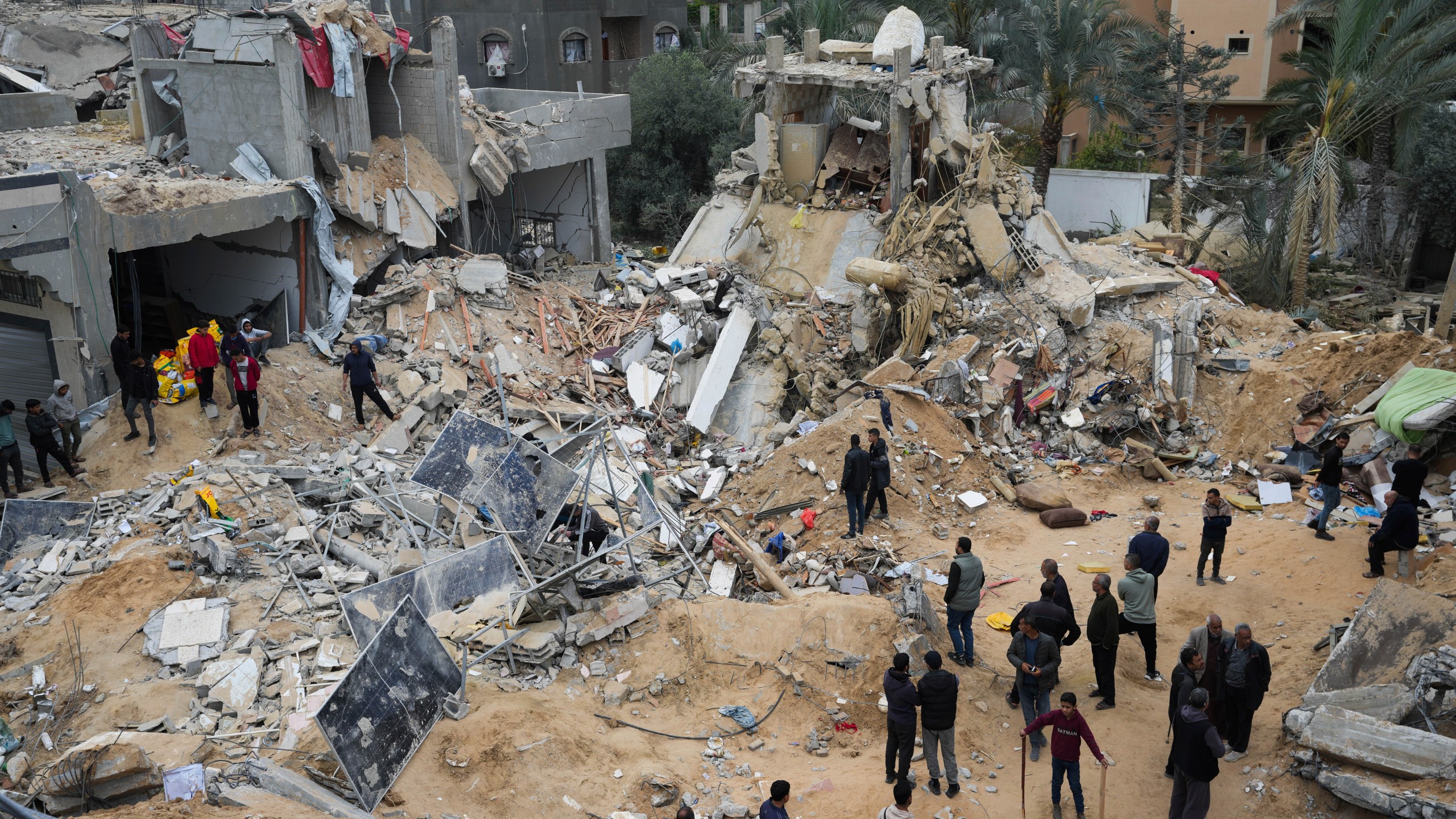 Palestinians look at a residential building destroyed in an Israeli strike in Deir al Balah on Monday, March 25, 2024. (AP Photo/Abdel Kareem Hana)
