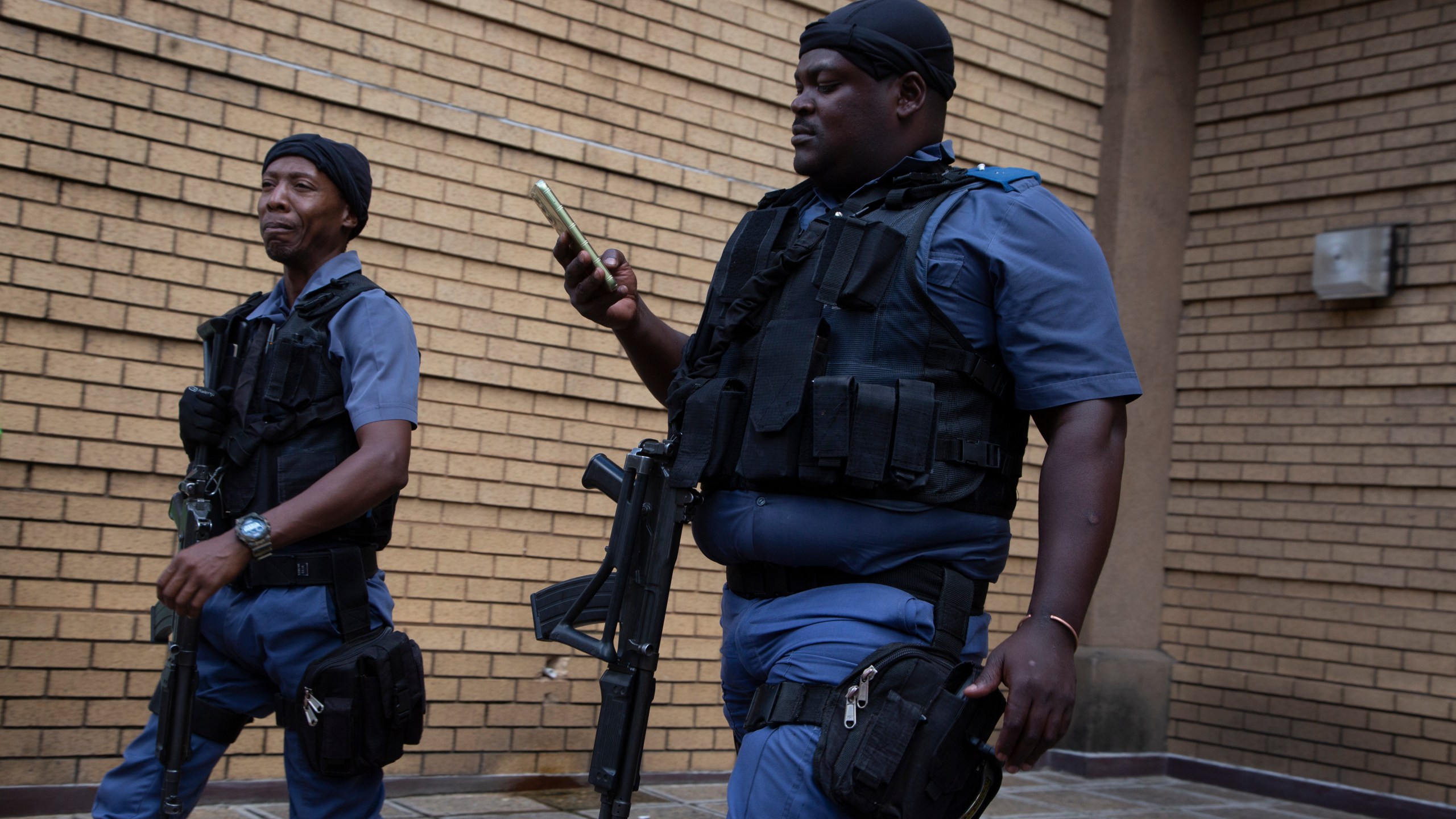Armed police patrol outside the High Court in Pretoria, South Africa, Monday March 25, 2024. South African prosecutors say they intend to charge the Parliament speaker with corruption. They allege she took $135,000 and a wig in bribes from an unnamed person over a three-year period while she was defense minister. (AP Photo/Denis Farrell)