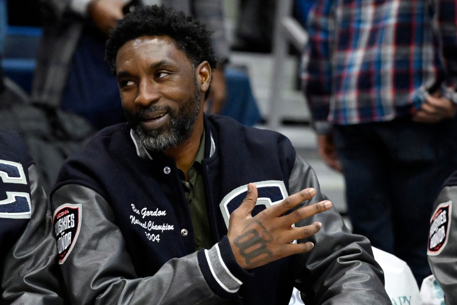 FILE- Former UConn and NBA player Ben Gordon sits on the sideline during a ceremony honoring the 2004 men's championship basketball team during halftime of an NCAA college basketball game, Sunday, Jan. 28, 2024, in Hartford, Conn. Gordon, who was arrested after a Connecticut juice shop disturbance last year, could see the charges erased from his record, under a probation program approved by a judge Monday, March 25, 2024. (AP Photo/Jessica Hill, File)