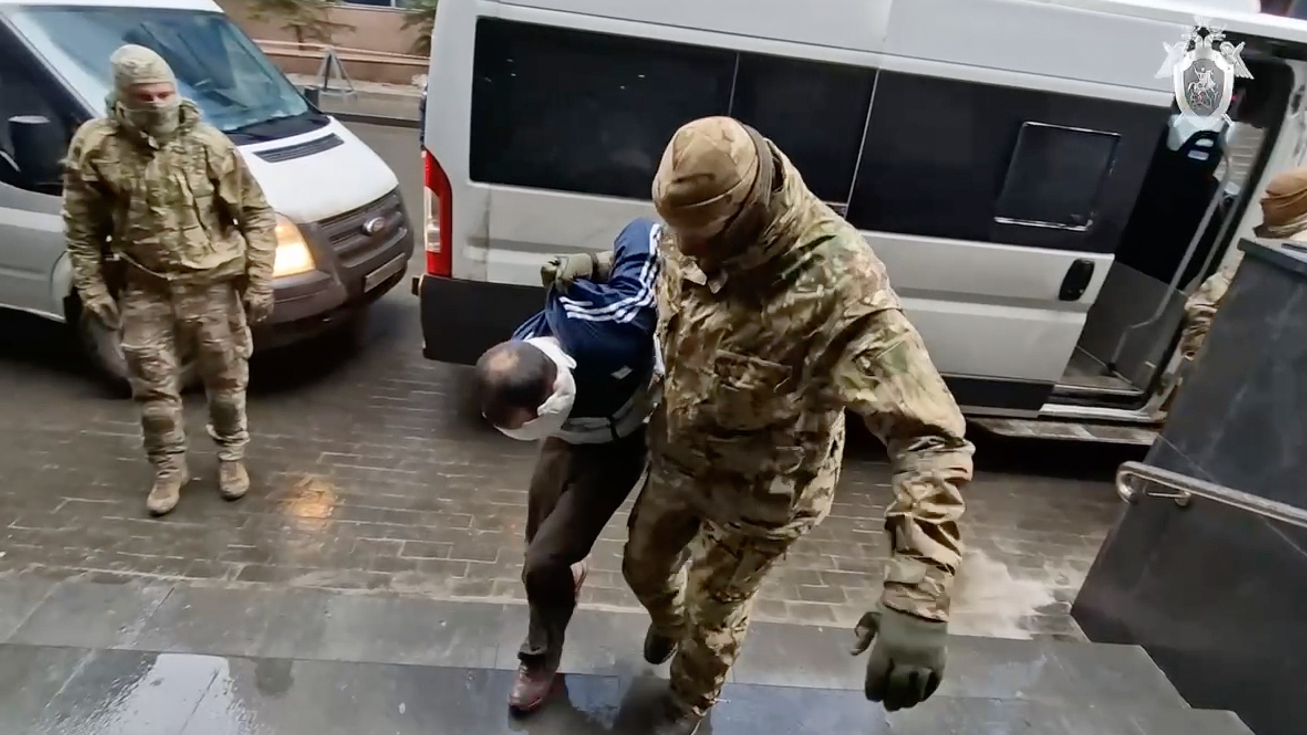 In this photo taken from video released by Investigative Committee of Russia on Sunday, March 24, 2024, a suspect in the Crocus City Hall shooting on Friday is escorted to the Russian Investigative Committee headquarters in Moscow, Russia. (Investigative Committee of Russia via AP)