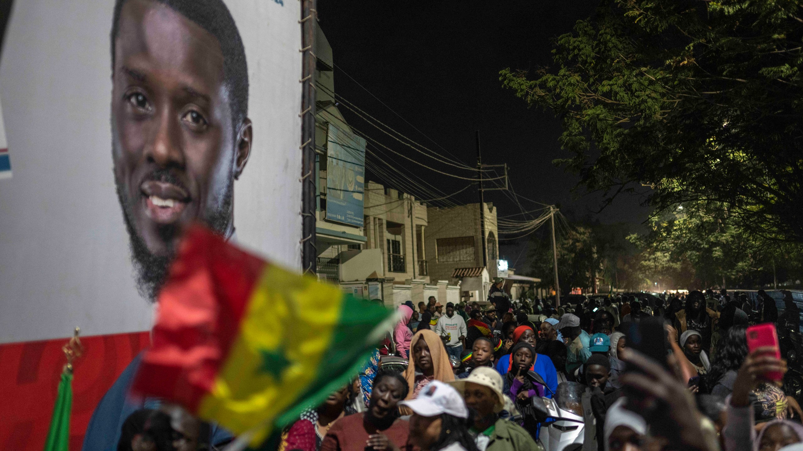 Supporters of presidential candidate Bassirou Diomaye Faye gather outside his campaign headquarters as they await the results of the presidential election, in Dakar, Senegal, Sunday, March 24, 2024. (AP Photo/Mosa'ab Elshamy)