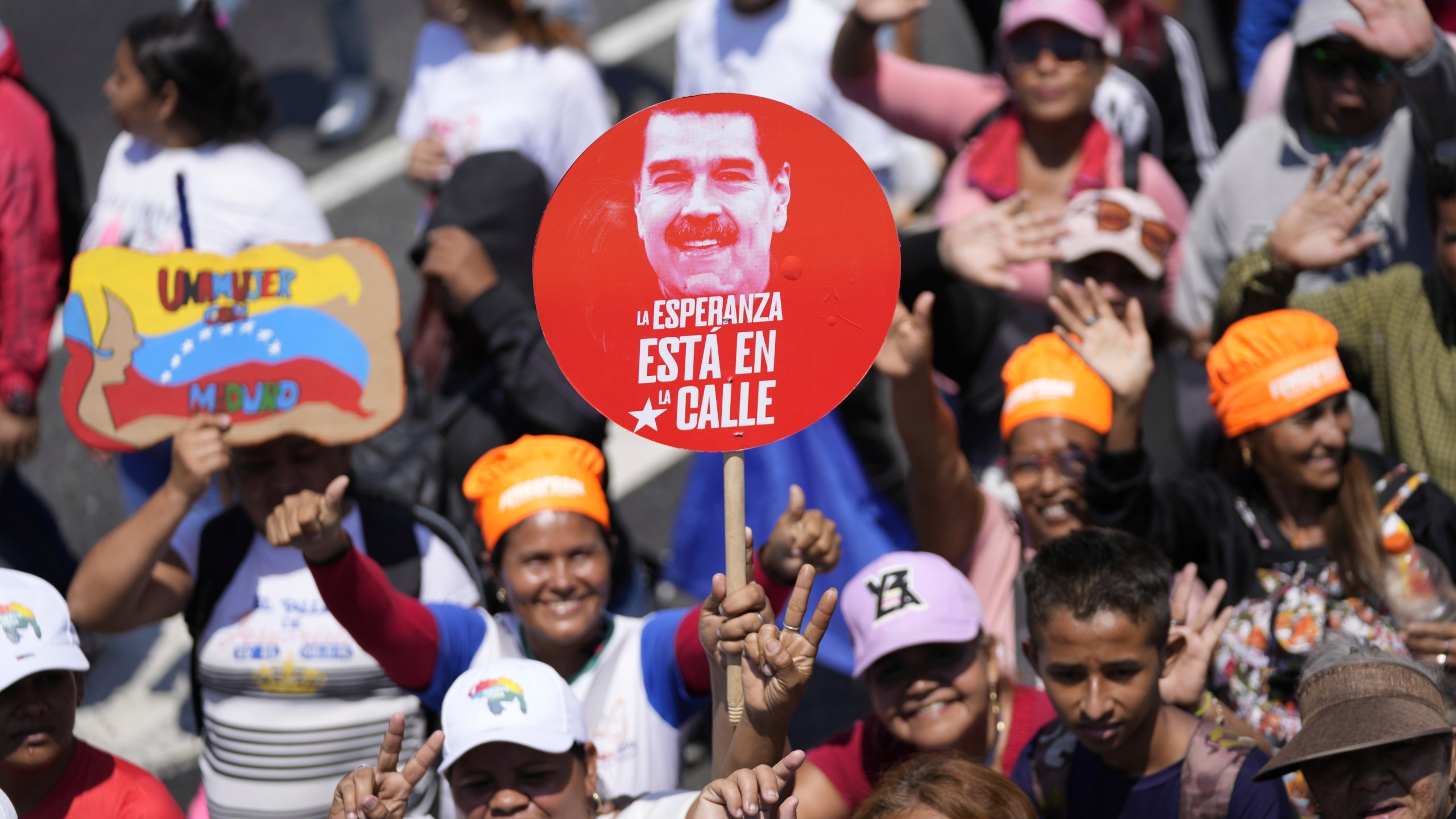 Government supporters march to the National Election Commission (CNE) where President Nicolas Maduro will formalize his candidacy to run again for president in Caracas, Venezuela, Monday, March 25, 2024. Elections are set for July 28. The sign reads in Spanish "Hope is in the street." (AP Photo/Matias Delacroix)